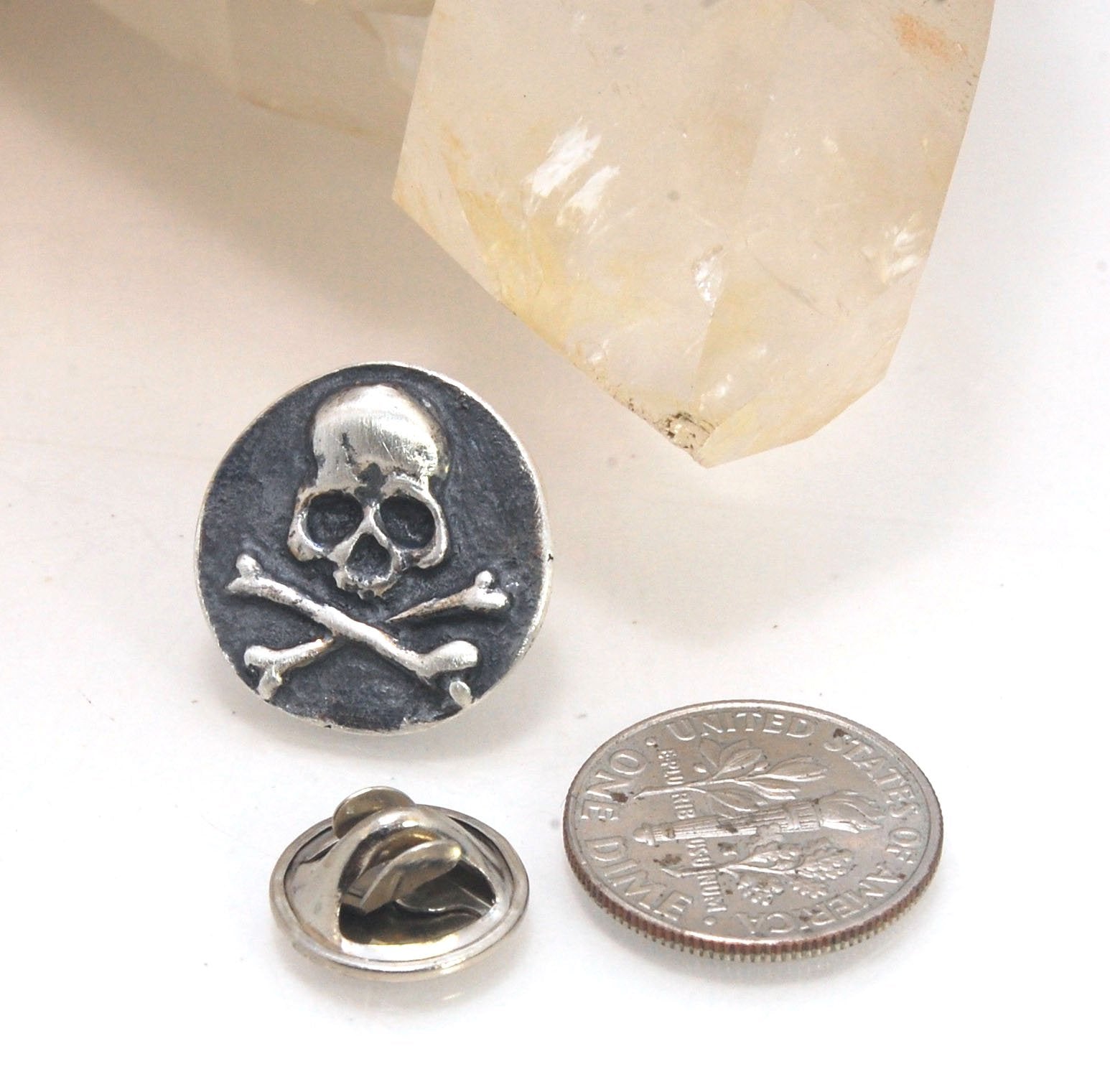 Skullbones Coin Lapel Pin These solid sterling silver SkullBones Coin Lapel Pin can also be worn as a Tie Tack. This Skullbones Coin is wax carved by hand and cast using the ancient process of Lost Wax to cast them in sterling silver. I then made a mold,