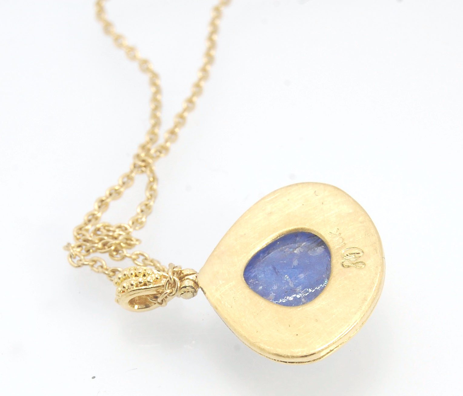 Blue Drop Tanzanite Cabochon 18k Gold Granulation Pendant and 14k 18" Chain This super blue teardrop-shaped Tanzanite is bezel-set in rich 18k gold bezel setting surrounded by 18k gold granulation with a granulated bail that has been riveted on for more m