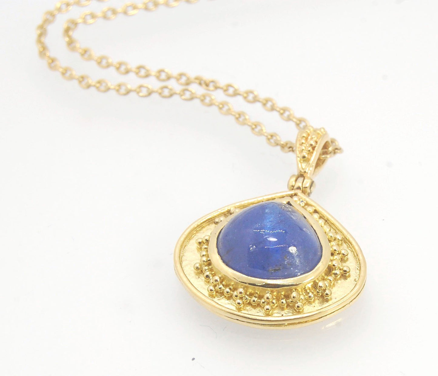 Blue Drop Tanzanite Cabochon 18k Gold Granulation Pendant and 14k 18" Chain This super blue teardrop-shaped Tanzanite is bezel-set in rich 18k gold bezel setting surrounded by 18k gold granulation with a granulated bail that has been riveted on for more m