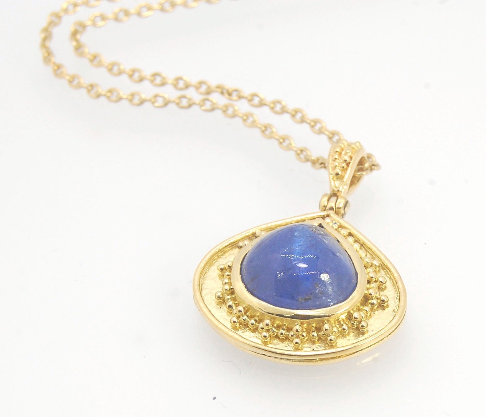 Blue Drop Tanzanite Cabochon 18k Gold Granulation Pendant and 14k 18" Chain This super blue teardrop-shaped Tanzanite is bezel-set in rich 18k gold bezel setting surrounded by 18k gold granulation with a granulated bail that has been riveted on for more m
