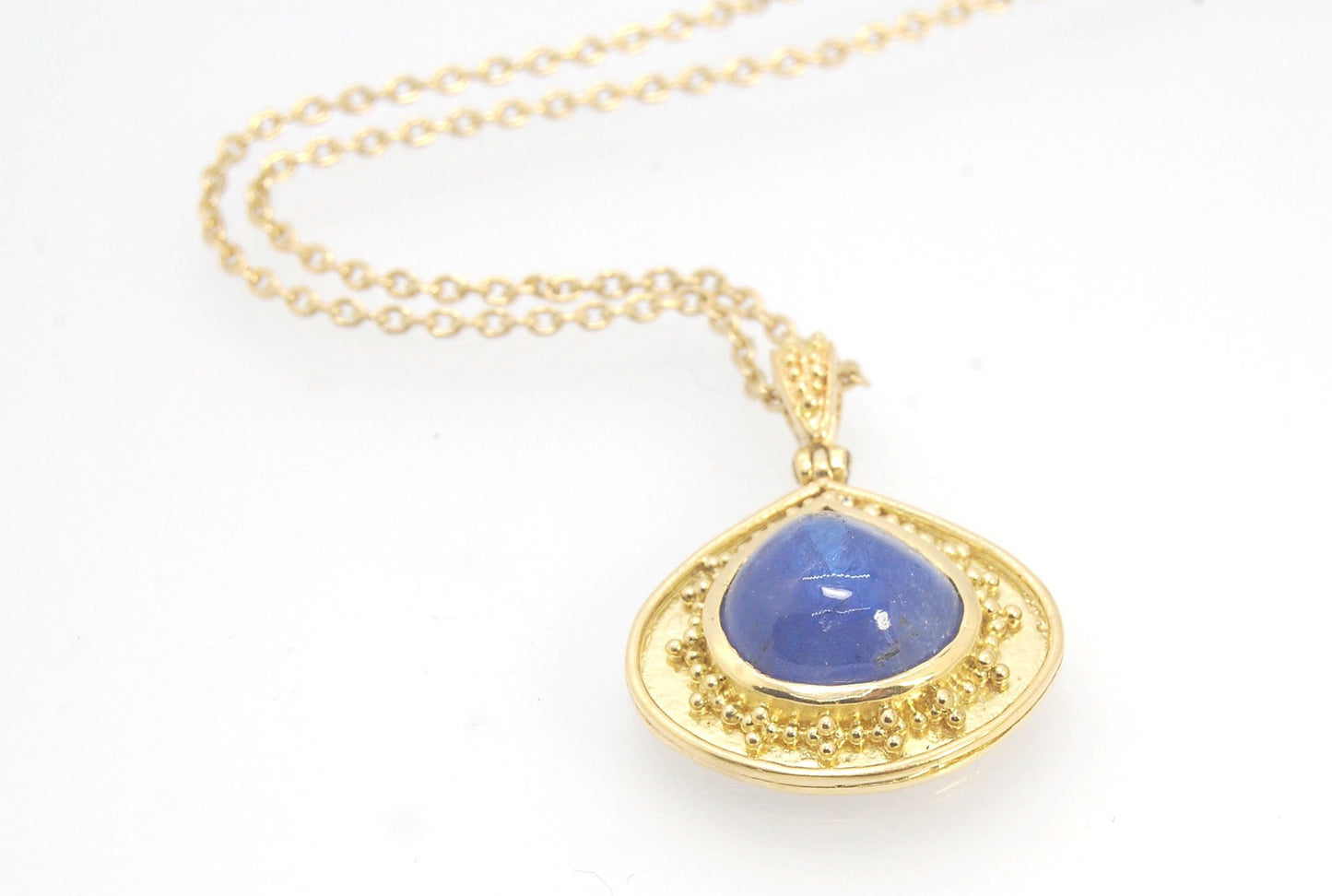 Blue Drop Tanzanite Cabochon 18k Gold Granulation Pendant and 14k 18" Chain This super blue teardrop-shaped Tanzanite is bezel-set in rich 18k gold bezel setting surrounded by 18k gold granulation with a granulated bail that has been riveted on for more m