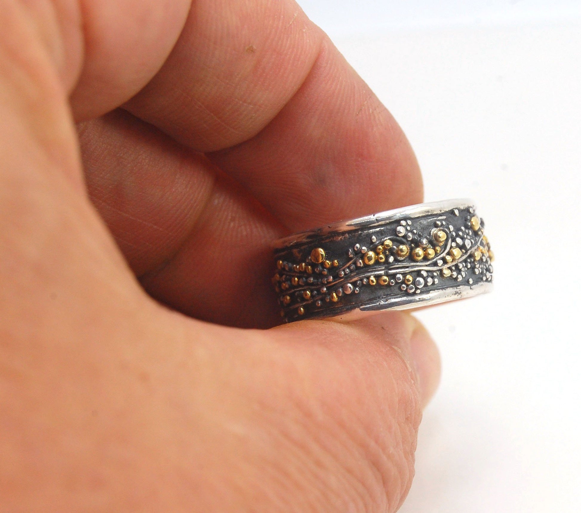 Cosmic Waves 18k and Fine Silver Granulation Ring 11mm wide This is very similar to the ring I made during the segment of “A Craftsman’s Legacy” on PBS a few years ago but with 18k gold granules of varying sizes. I am happy to make one for you in your siz
