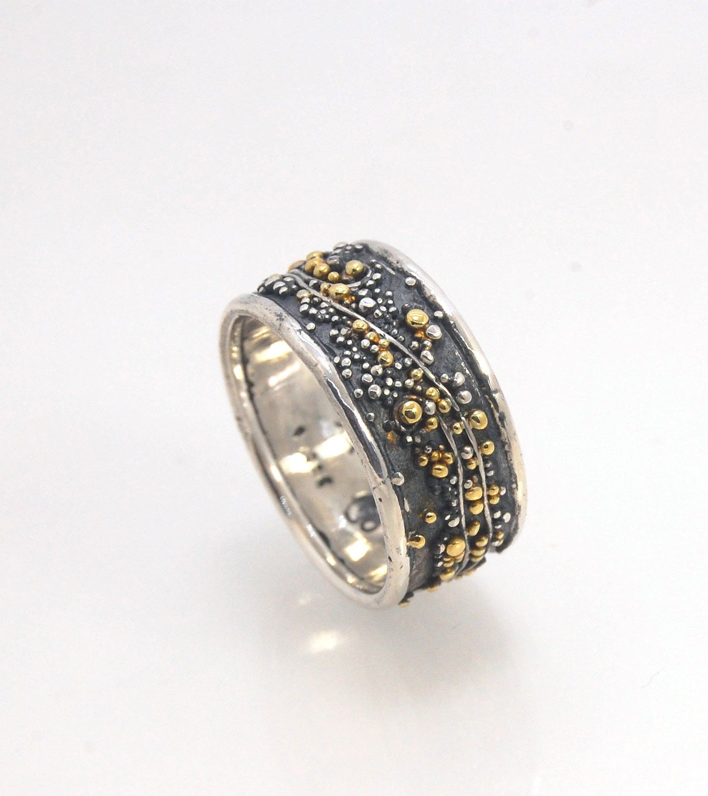 Cosmic Waves 18k and Fine Silver Granulation Ring 11mm wide This is very similar to the ring I made during the segment of “A Craftsman’s Legacy” on PBS a few years ago but with 18k gold granules of varying sizes. I am happy to make one for you in your siz