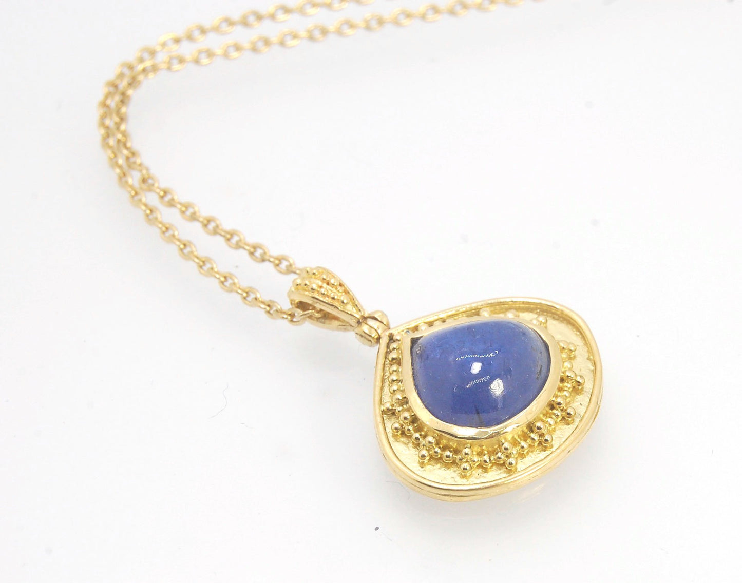 Blue Drop Tanzanite Cabochon 18k Gold Granulation Pendant and 14k 18" Chain This super blue teardrop-shaped Tanzanite is bezel-set in rich 18k gold bezel setting surrounded by 18k gold granulation with a granulated bail that has been riveted on for more m