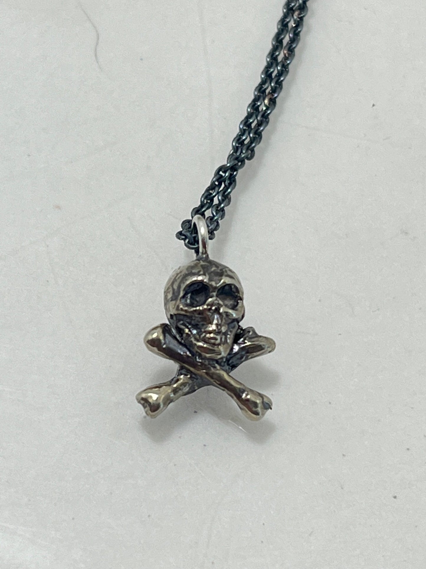 Jolly Roger Pendant This solid sterling silver Jolly Roger Pendant is wax carved by hand and cast using the ancient process of Lost Wax casting. I then made a mold, which I can inject with wax and make wax copies of the Jolly Roger Pendant and cast a lot