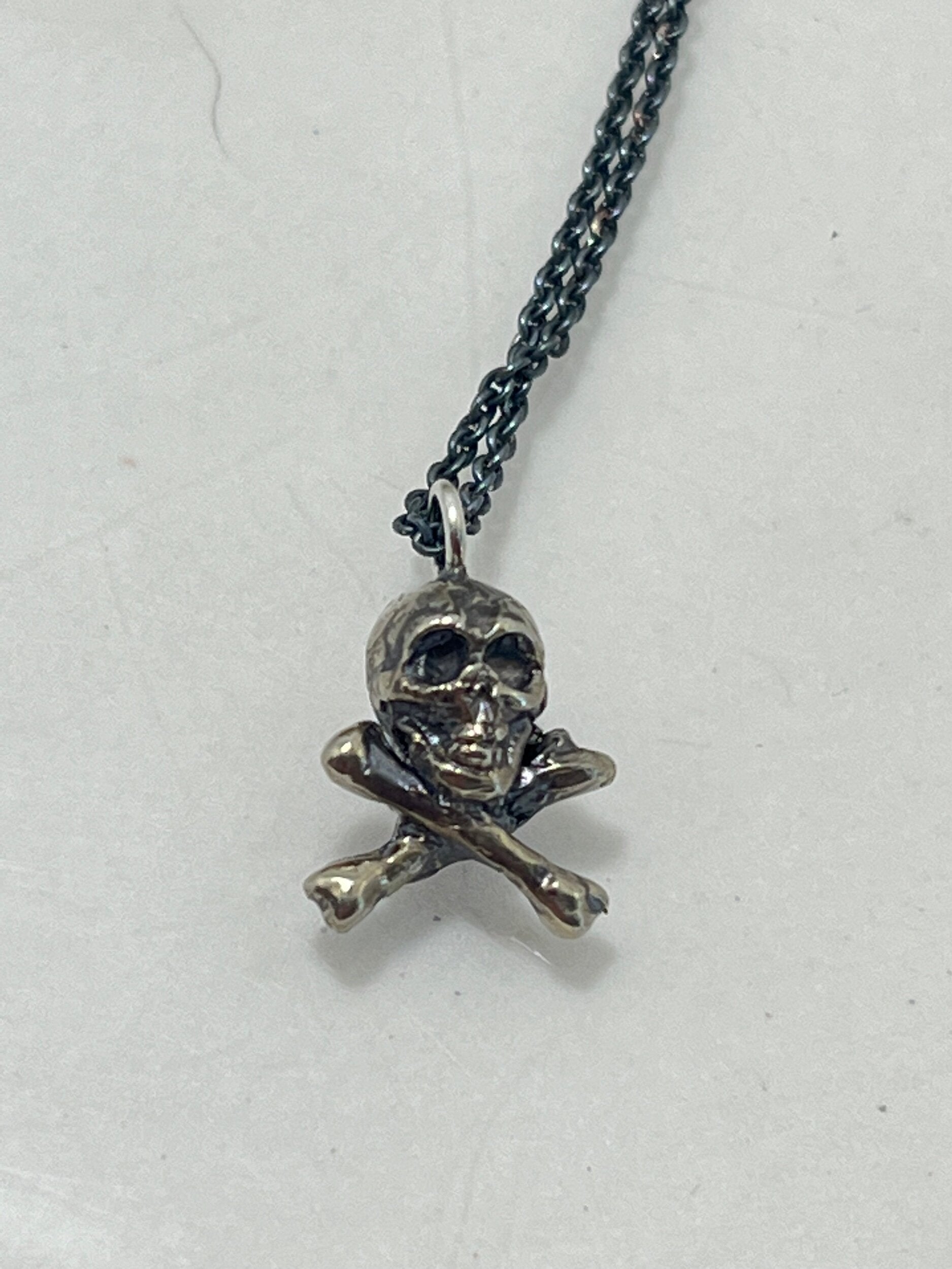 Jolly Roger Pendant This solid sterling silver Jolly Roger Pendant is wax carved by hand and cast using the ancient process of Lost Wax casting. I then made a mold, which I can inject with wax and make wax copies of the Jolly Roger Pendant and cast a lot