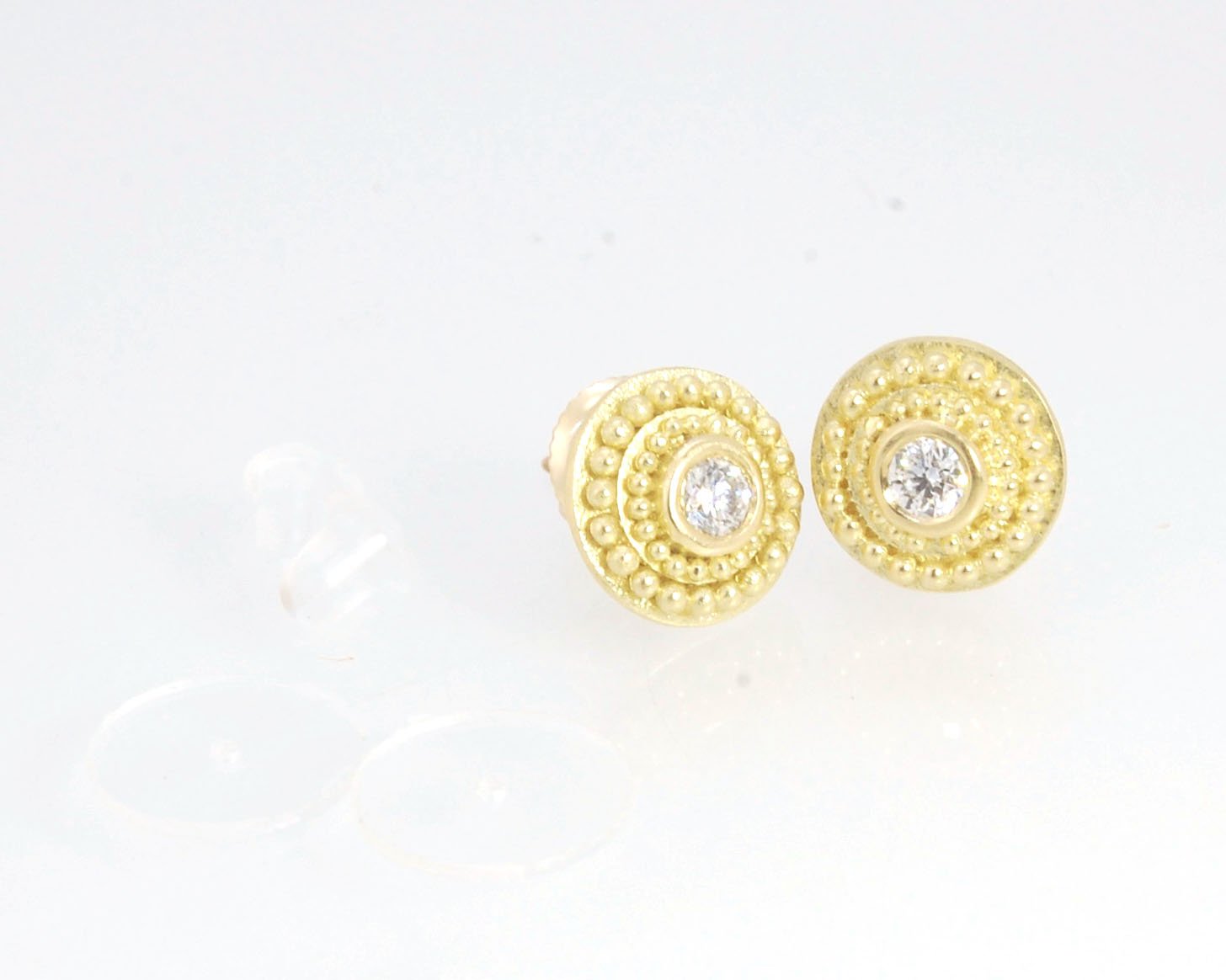 Diamond Disc Post Earrings - 18k Gold Granulation with 14k screw backs These Diamond Disc Stud Earrings are Classically-inspired 18k granulation. With 2 ethically-mined, .10ct , 3mm, Sl1, F+ round diamonds bezel-set in 18k a double ring of 18k gold granul