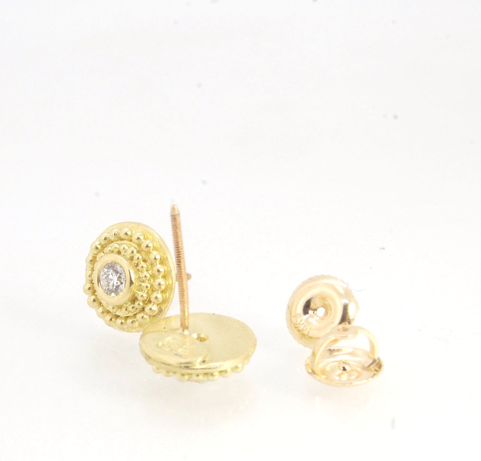 Diamond Disc Post Earrings - 18k Gold Granulation with 14k screw backs These Diamond Disc Stud Earrings are Classically-inspired 18k granulation. With 2 ethically-mined, .10ct , 3mm, Sl1, F+ round diamonds bezel-set in 18k a double ring of 18k gold granul