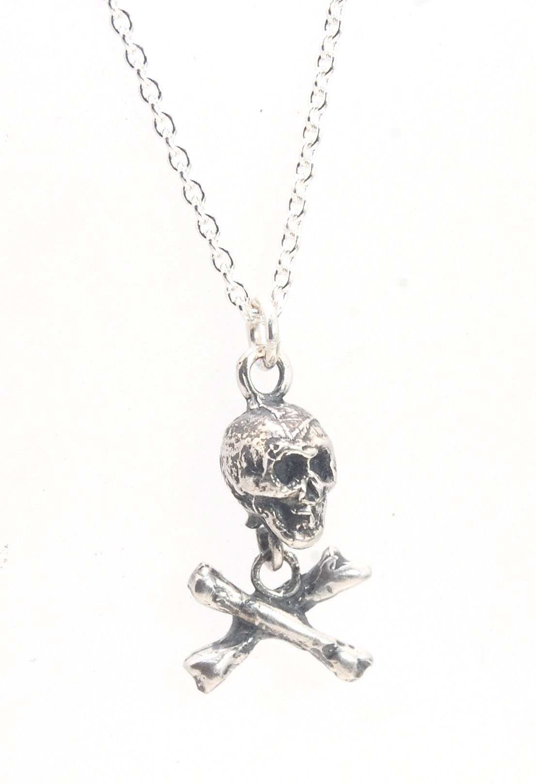 Skull & Crossbones Dangle Pendant This solid sterling silver Skull & Crossbones dangle pendant is wax carved by hand and cast using the ancient process of Lost Wax casting. I then made a mold, which I can inject with wax and make wax copies of the Skull a