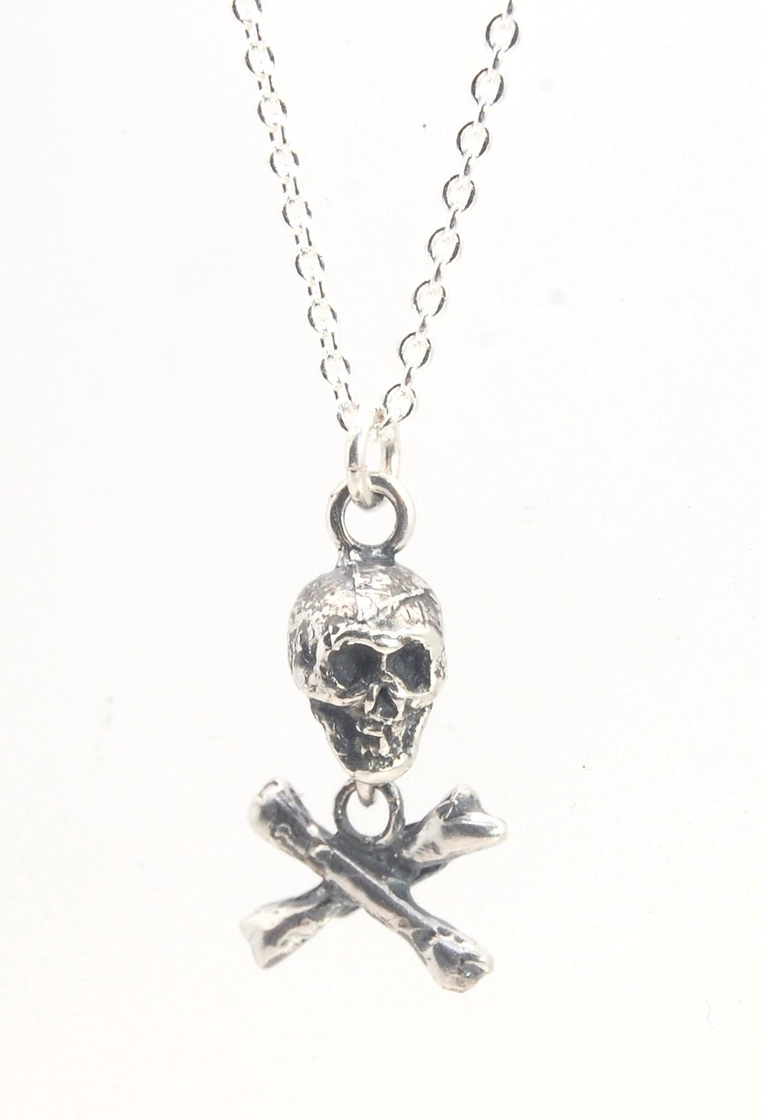 Skull & Crossbones Dangle Pendant This solid sterling silver Skull & Crossbones dangle pendant is wax carved by hand and cast using the ancient process of Lost Wax casting. I then made a mold, which I can inject with wax and make wax copies of the Skull a