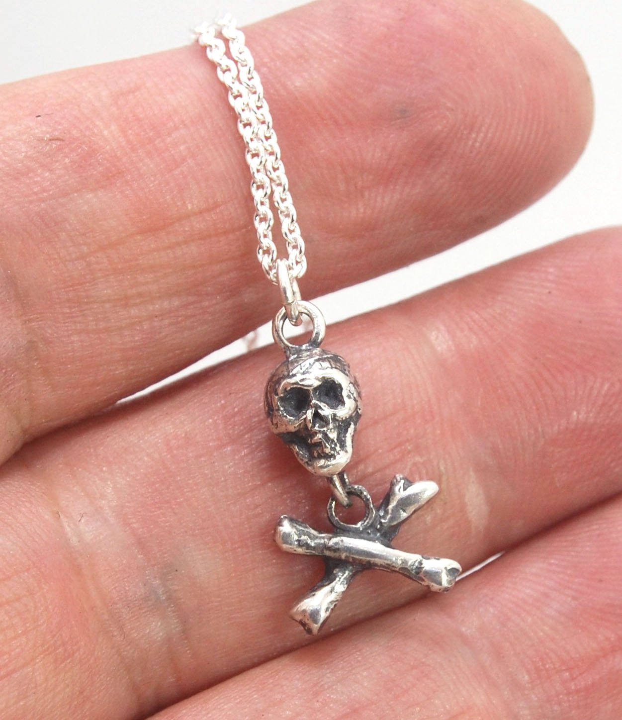 Skull & Crossbones Dangle Pendant This solid sterling silver Skull & Crossbones dangle pendant is wax carved by hand and cast using the ancient process of Lost Wax casting. I then made a mold, which I can inject with wax and make wax copies of the Skull a