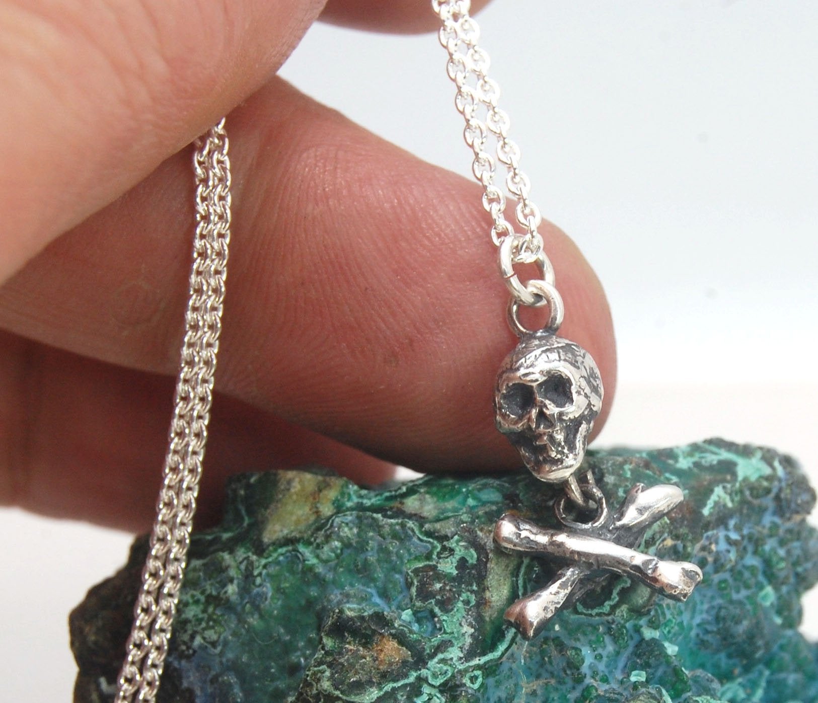 Skull & Crossbones Dangle Pendant This solid sterling silver Skull & Crossbones dangle pendant is wax carved by hand and cast using the ancient process of Lost Wax casting. I then made a mold, which I can inject with wax and make wax copies of the Skull a