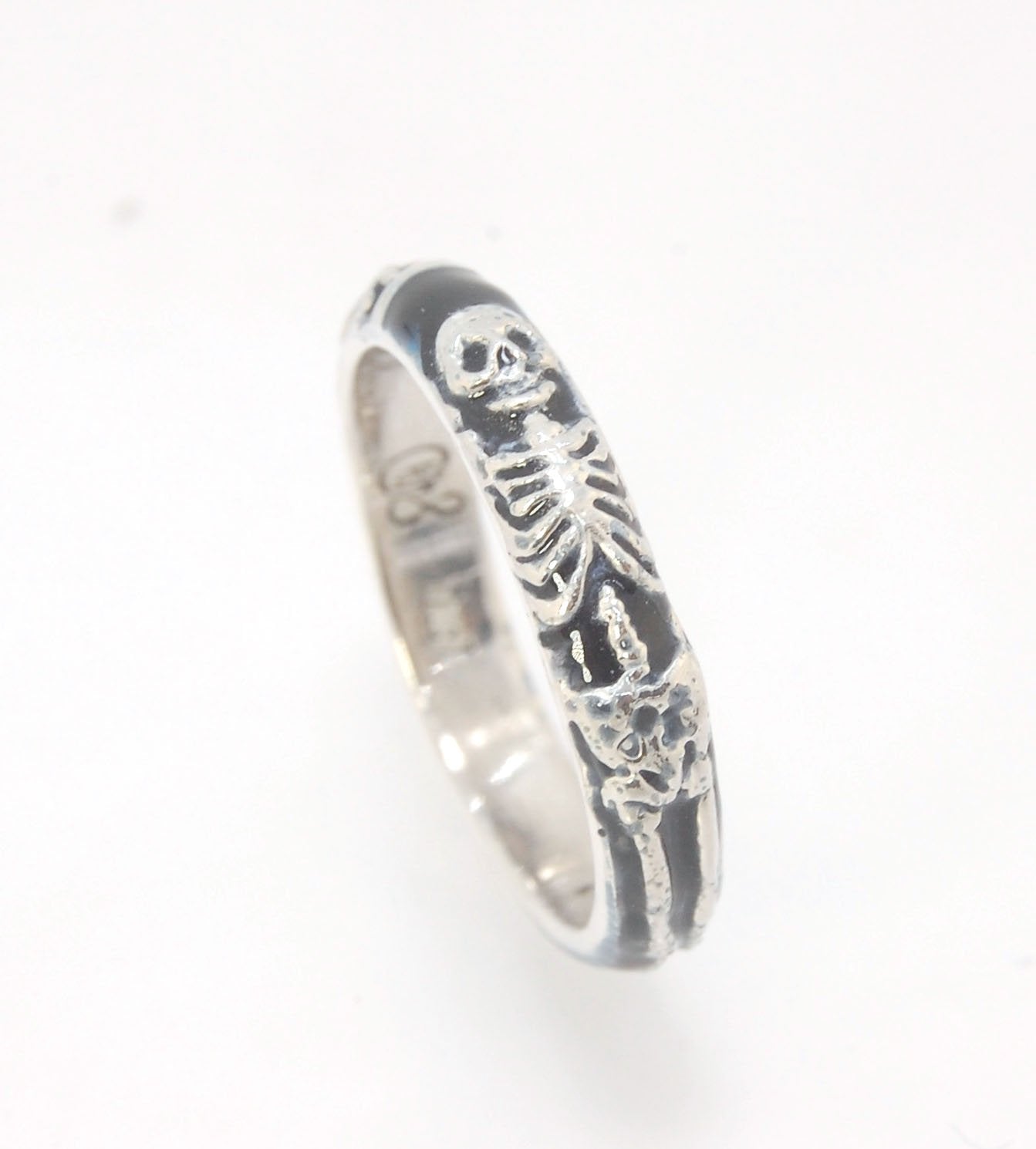 Memento Mori Skeleton Ring - Medium - 4mm - Enameled This is the middle width of my Memento Mori skeleton rings at 4mm wide. The Skeleton is flanked by crossed bones on one side and an hourglass on the other. Each ring in this collection is carved in wax