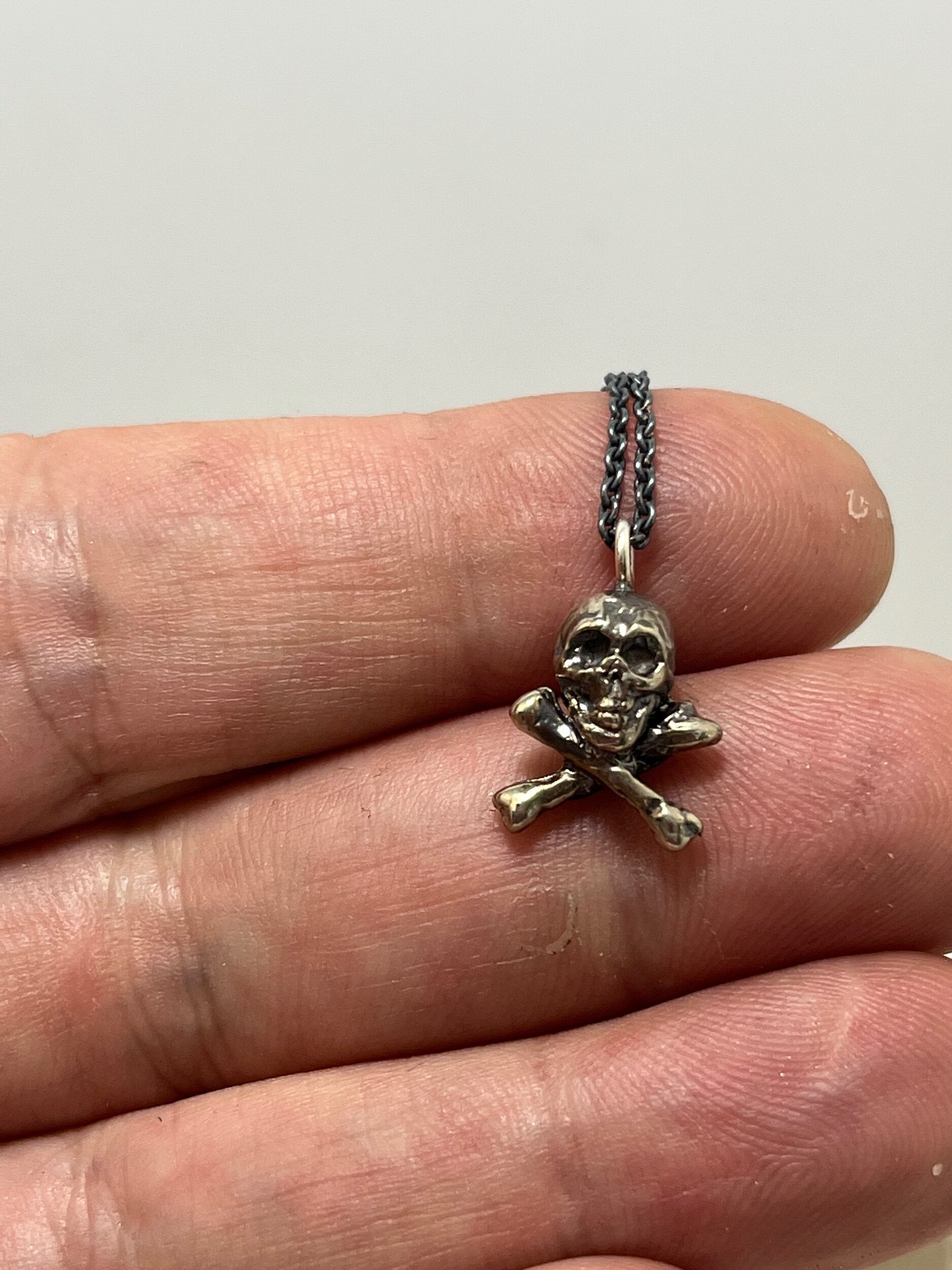 Jolly Roger Pendant This solid sterling silver Jolly Roger Pendant is wax carved by hand and cast using the ancient process of Lost Wax casting. I then made a mold, which I can inject with wax and make wax copies of the Jolly Roger Pendant and cast a lot