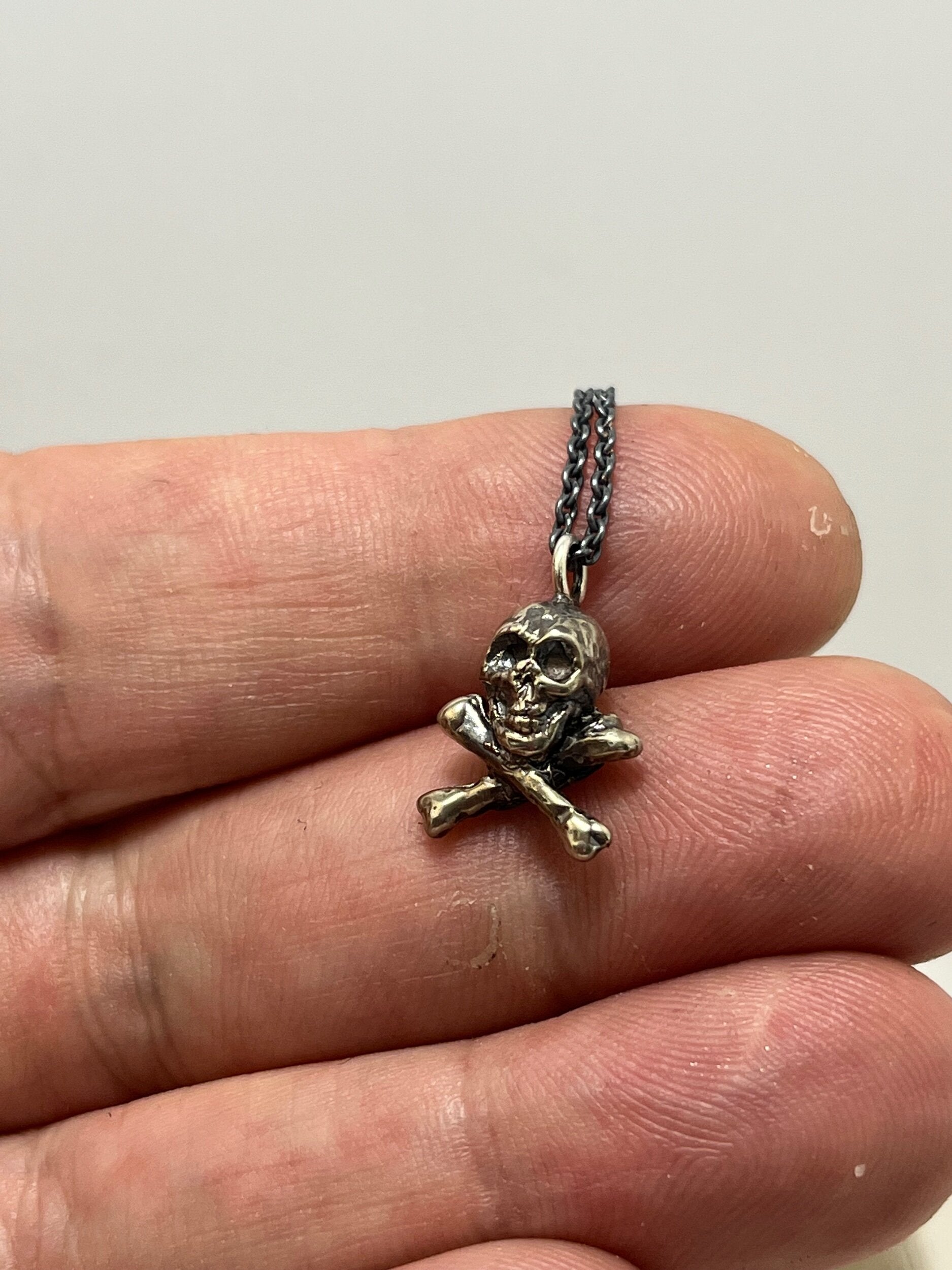 Jolly Roger Pendant This solid sterling silver Jolly Roger Pendant is wax carved by hand and cast using the ancient process of Lost Wax casting. I then made a mold, which I can inject with wax and make wax copies of the Jolly Roger Pendant and cast a lot