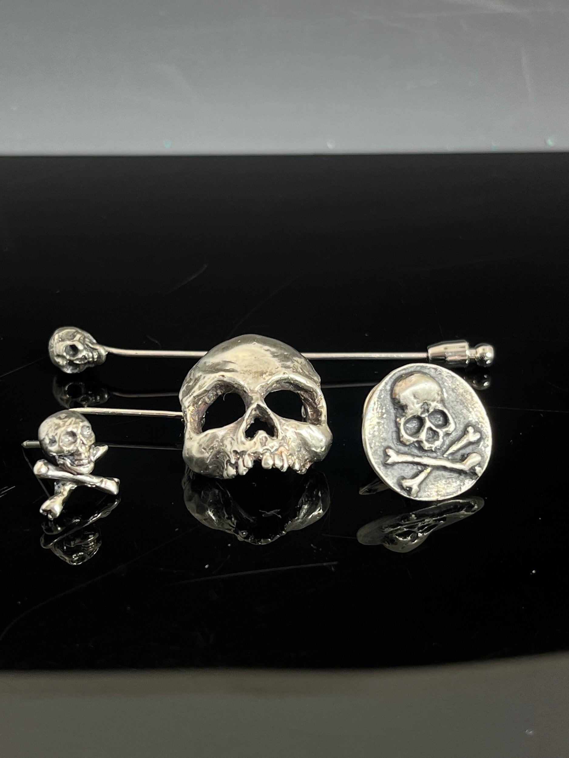 Yorick Skull Stick Pin This Skull Stick Pin is just darling if you like weird stuff. This Skull is wax carved by hand and cast using the ancient process of Lost Wax to cast them in sterling silver. I then made a mold, which I can inject with wax and make