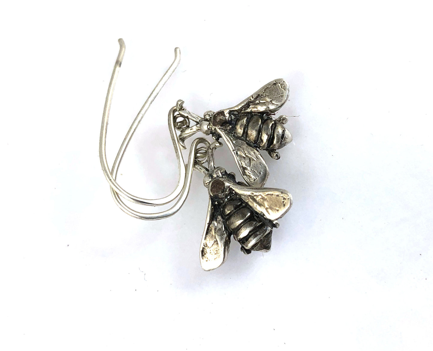 Bee Earrings in Sterling Silver Bee Earrings in Sterling Silver with a French Hook. These bees were so fun to carve!I carved the original bee in wax and then cast it using a lost wax process in sterling. I then made a mold of the sterling bee. Then inject