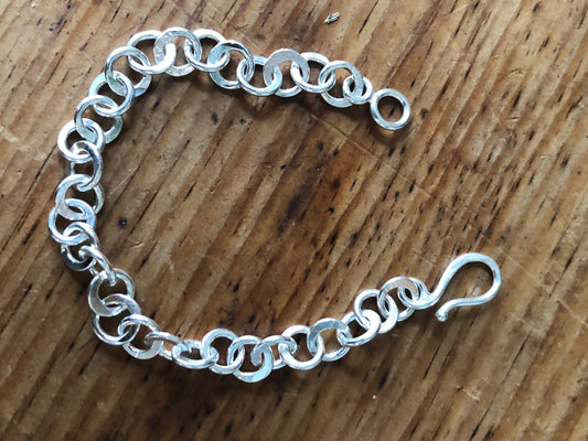 Moonshaped Silver Hammered Link Bracelet These are fun and eye-catching silver bracelets! They have a nice weight without being heavy. Each link is soldered and hammered in a moon pattern for a shimmery look. Each has a forged hook clasp. Each link is for