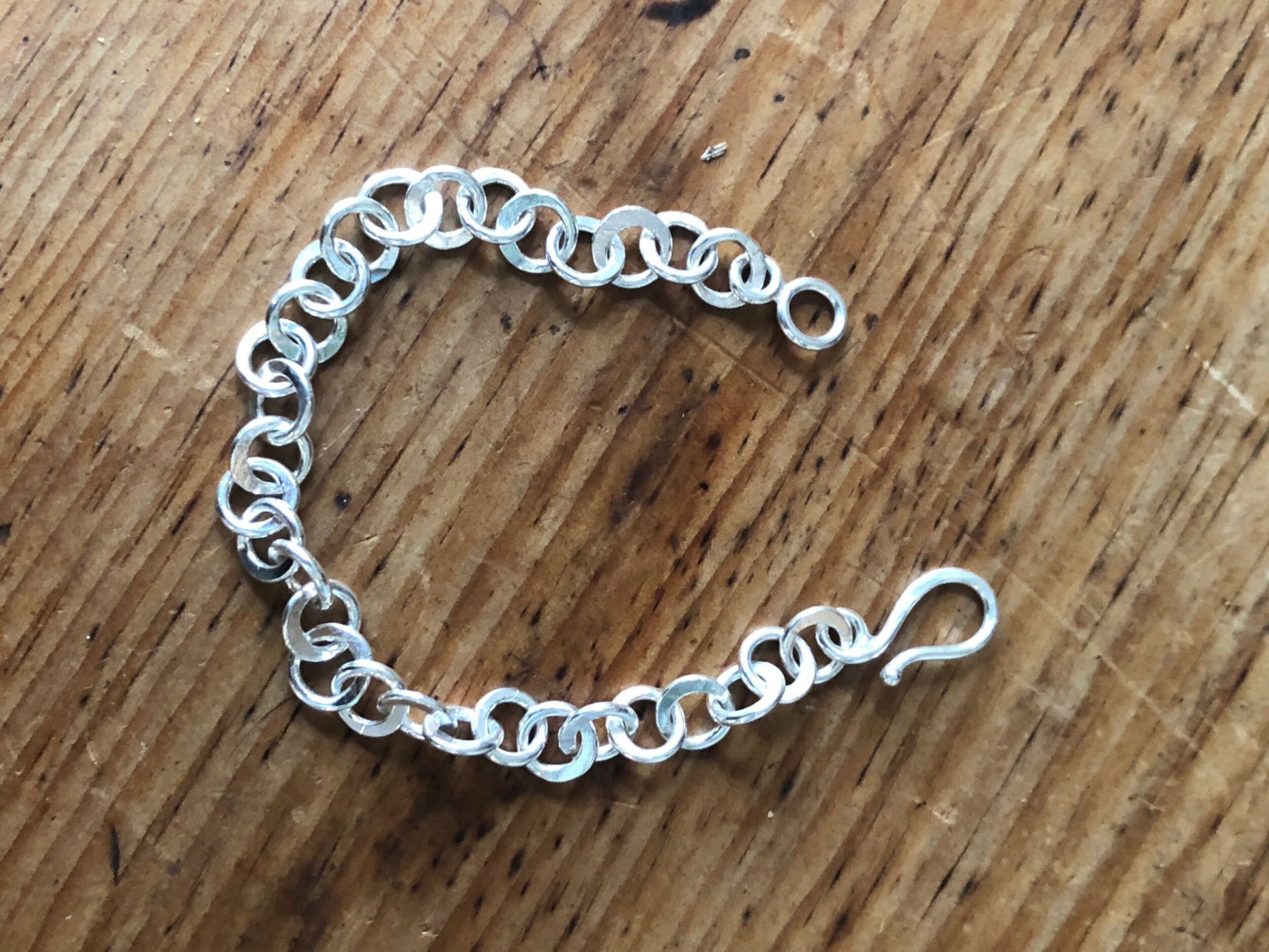 Moonshaped Silver Hammered Link Bracelet These are fun and eye-catching silver bracelets! They have a nice weight without being heavy. Each link is soldered and hammered in a moon pattern for a shimmery look. Each has a forged hook clasp. Each link is for