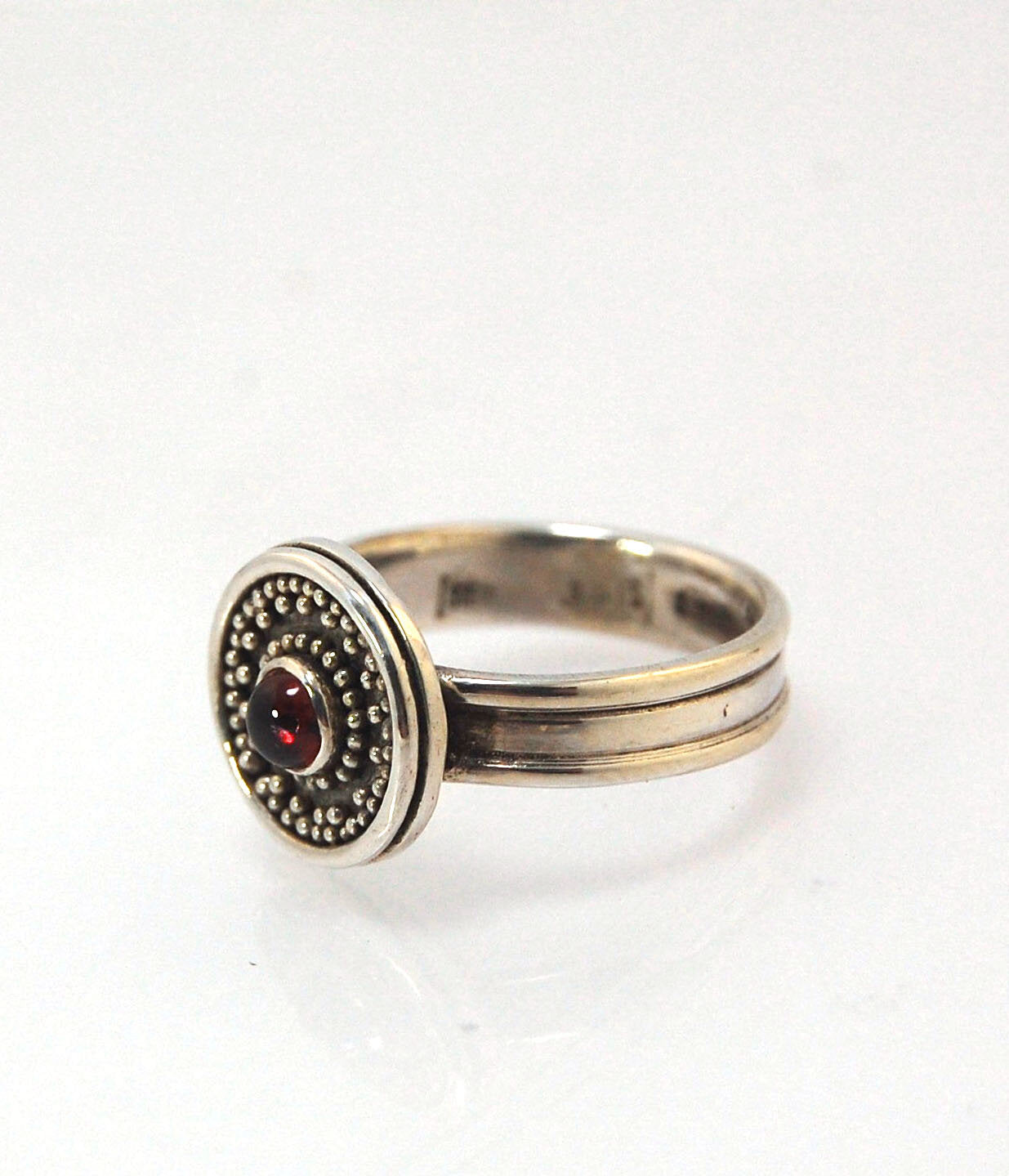 Garnet Granulation Shield Ring - size 7 This Garnet cabochon is bezel-set in a Fine Silver Starburst Pattern with a carved and cast Sterling shank band.Granulation is an ancient fusing process utilized for thousands of years by the Etruscans and Mycenaean