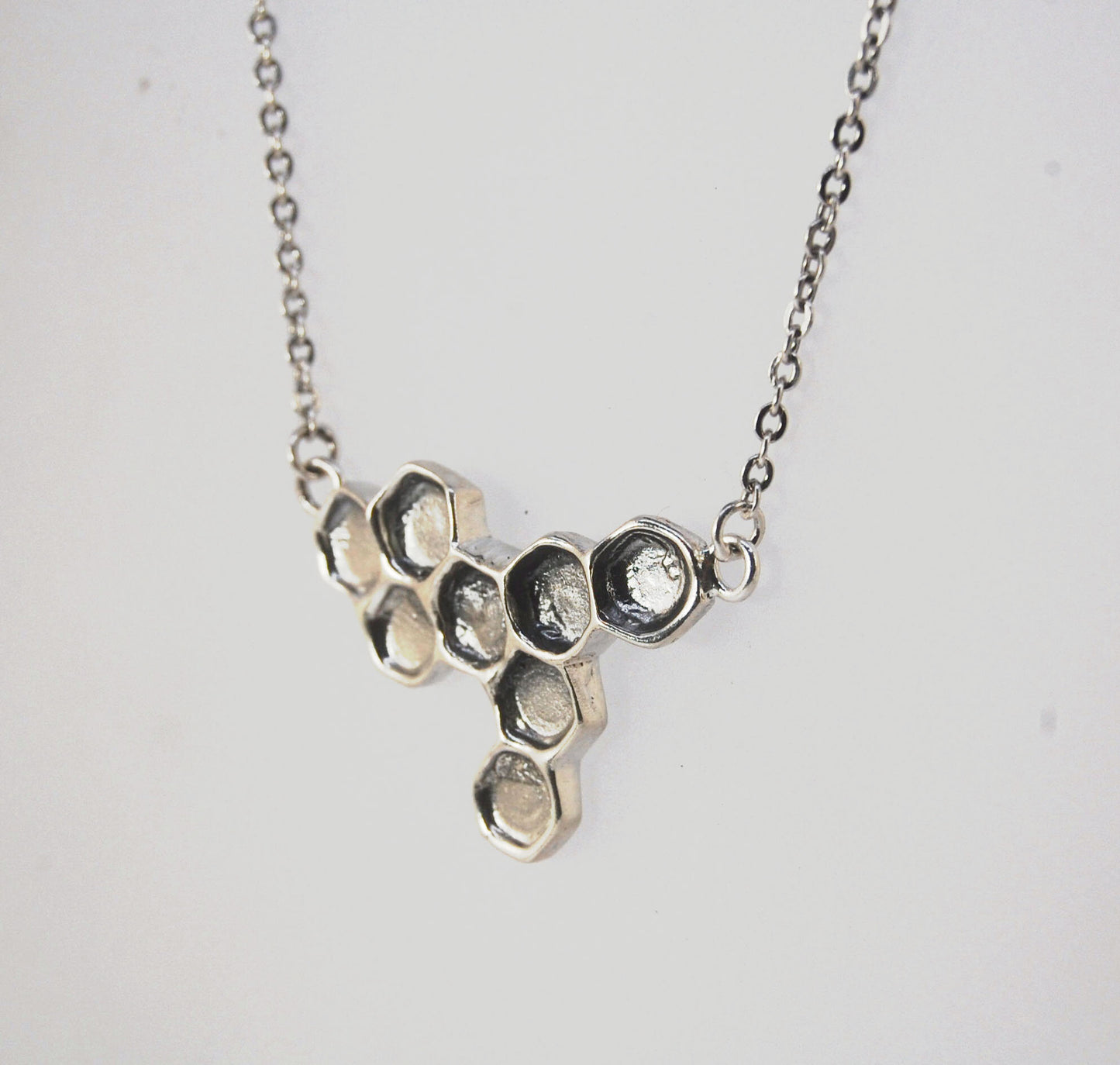 Honeycomb Necklace Honeycomb NecklaceThis Honeycomb Necklace has a great weight and shimmer. It was carved in wax and cast using the ancient lost-wax process in Sterling Silver. Inspired by our pollinator friends, the Bees, and the beauty they produce eve