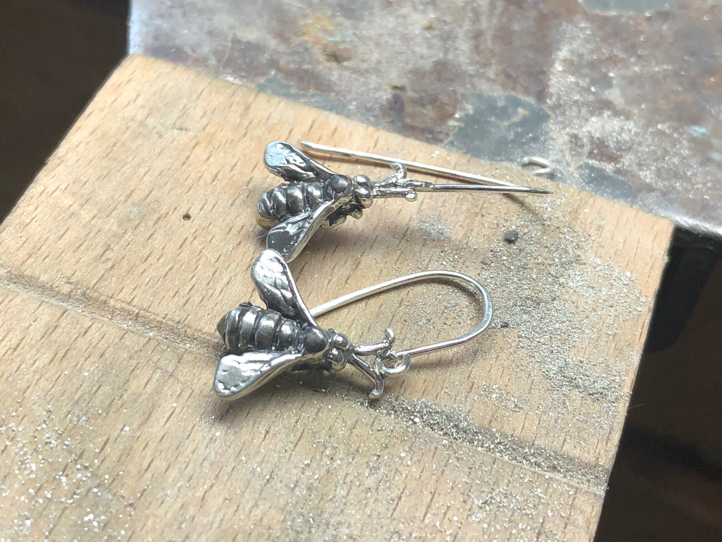 Bee Earrings in Sterling Silver Bee Earrings in Sterling Silver with a French Hook. These bees were so fun to carve!I carved the original bee in wax and then cast it using a lost wax process in sterling. I then made a mold of the sterling bee. Then inject