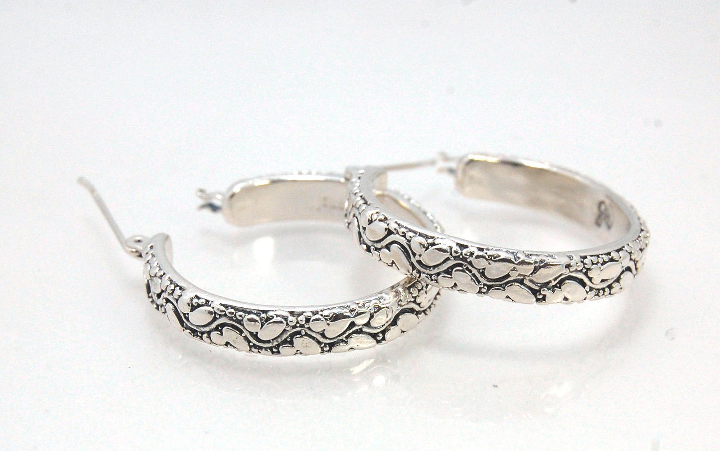 Oval Dots Hoop Earrings - Sterling Silver in 3 sizes These Hoops are made from an Oval and Dot pattern 4.7 mm wide band with ovals and heavy granules around a wavy center line. I made the original band in Fine silver using the process of Granulation. I th