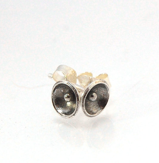 Poppy Post Earrings in Fine Silver These are tiny Fine Silver disks rounded into bowls with a tiny ball in the center to resemble a poppy. These are created using the ancient process of Granulation.6mmFine Silver Poppy, Sterling Post and EarnutMade to Ord