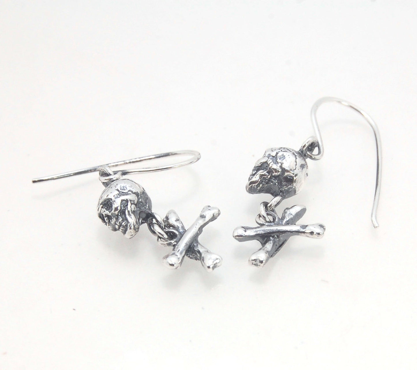 Skull & Bones Dangle Earrings These solid sterling silver Skull & Bones dangle earrings are wax carved by hand and cast using the ancient process of Lost Wax to cast them in sterling silver. I then made a mold, which I can inject with wax and make wax cop