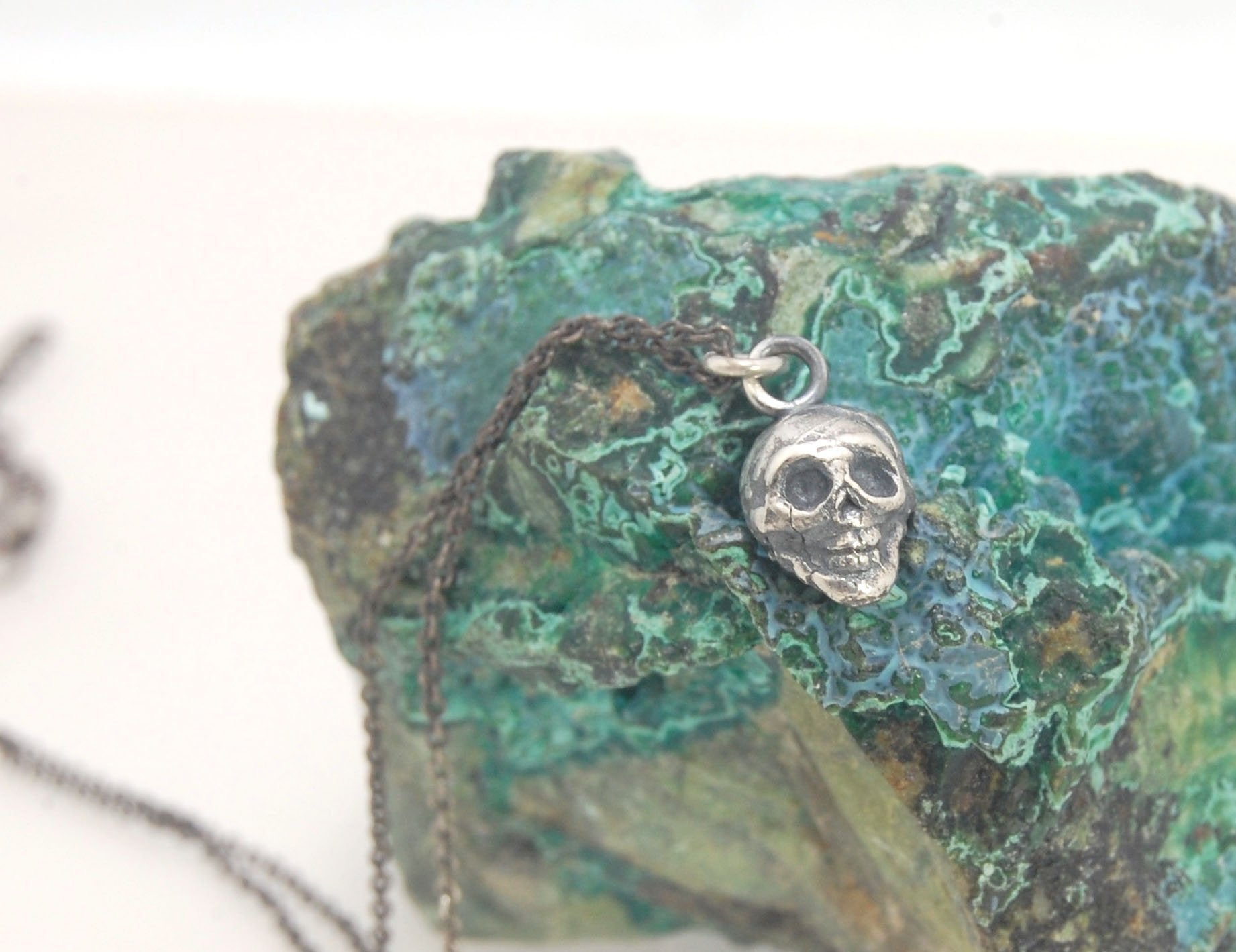 Tiny Skull Charm Pendant This solid sterling silver Skull Pendant is wax carved by hand and cast using the ancient process of Lost Wax casting. I then made a mold, which I can inject with wax and make wax copies of the Jolly Roger Pendant and cast a lot o