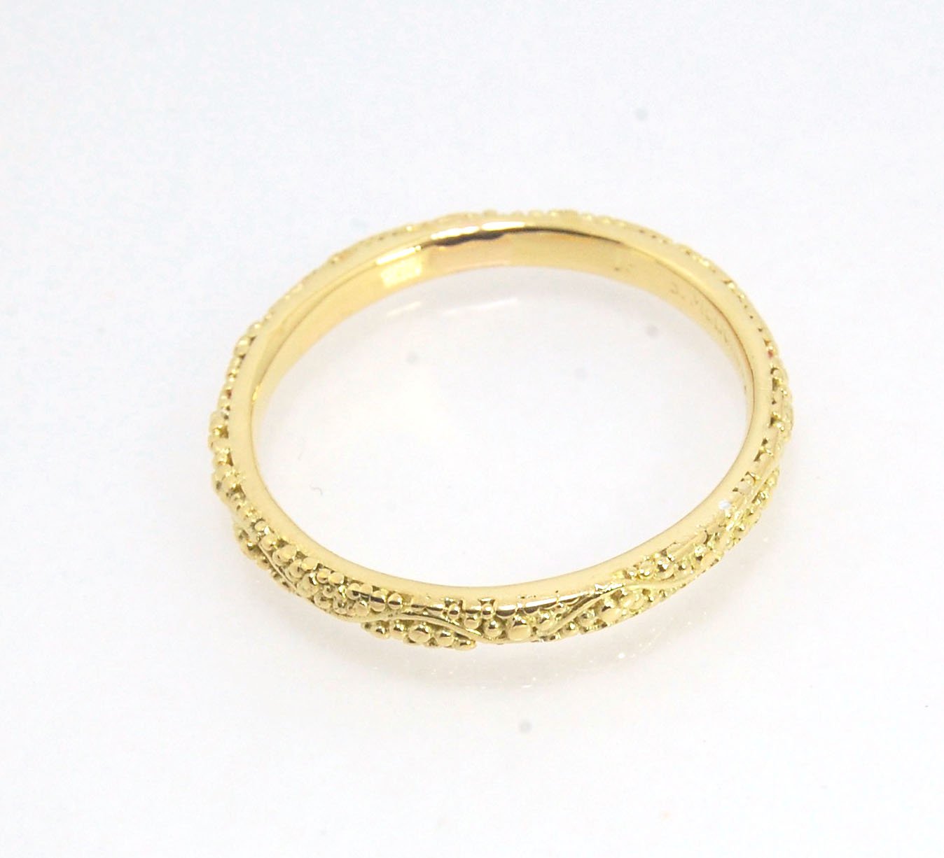 Twining Band in 18k Granulation This is a one-of-a-kind 18k ring handmade using the ancient process of granulation. The twining band is 2mm wide and has a continuous pattern around made with an ancient and unique process of granulation in 18k gold alloyed