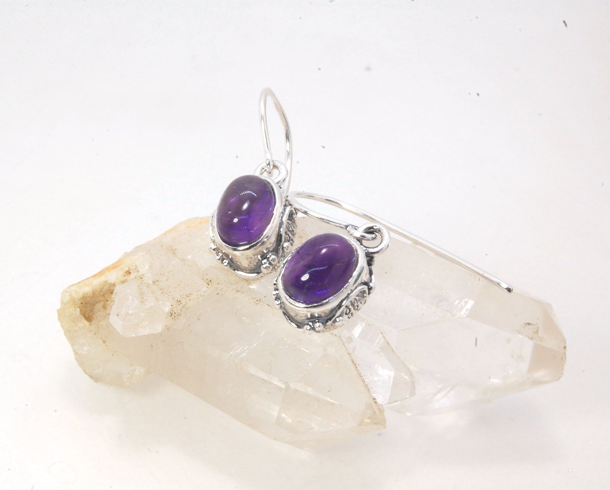 Oval Amethyst Earrings in Swirled silver bezel setting with french hook These are cast in my studio using the ancient technique of lost wax casting, and are molded in wax from an original granulated piece in fine silver. These sweet ovals are reminiscent