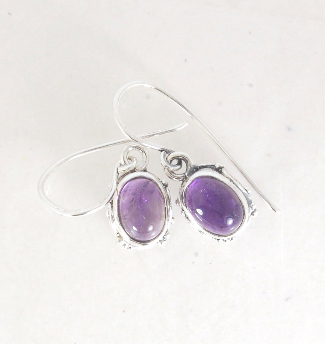 Oval Amethyst Earrings in Swirled silver bezel setting with french hook These are cast in my studio using the ancient technique of lost wax casting, and are molded in wax from an original granulated piece in fine silver. These sweet ovals are reminiscent