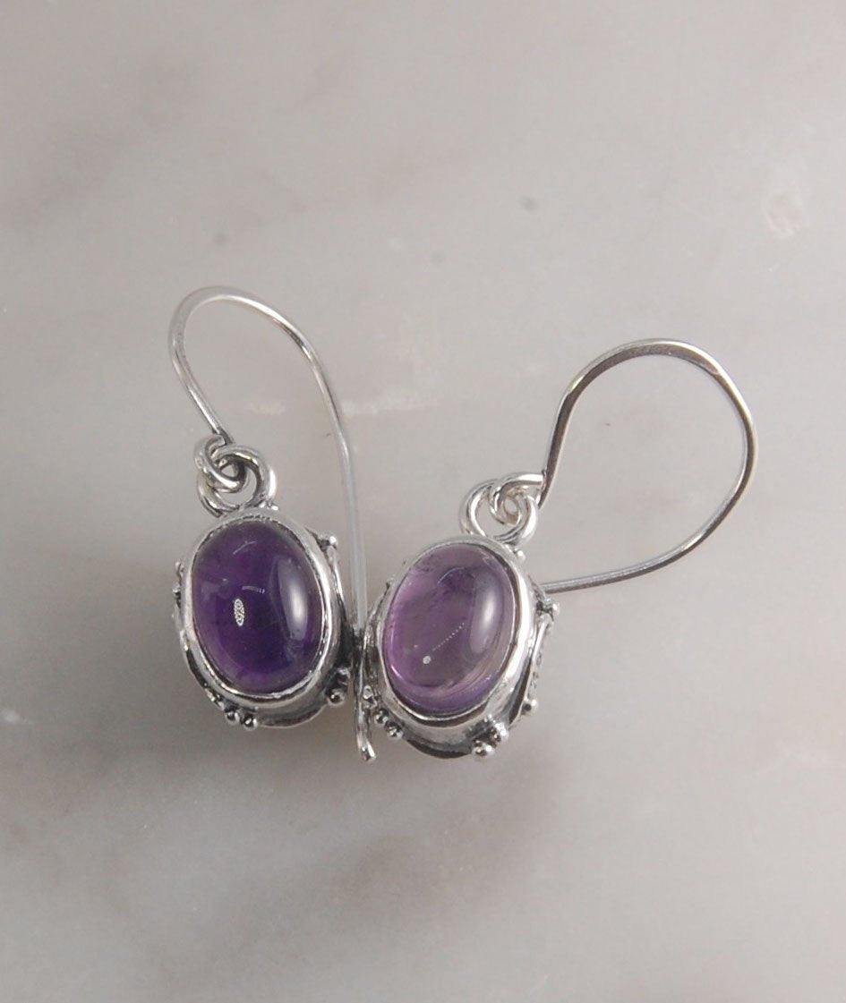 Oval Amethyst Earrings in Swirled silver bezel setting with french hook These are cast in my studio using the ancient technique of lost wax casting, and are molded in wax from an original granulated piece in fine silver. These sweet ovals are reminiscent