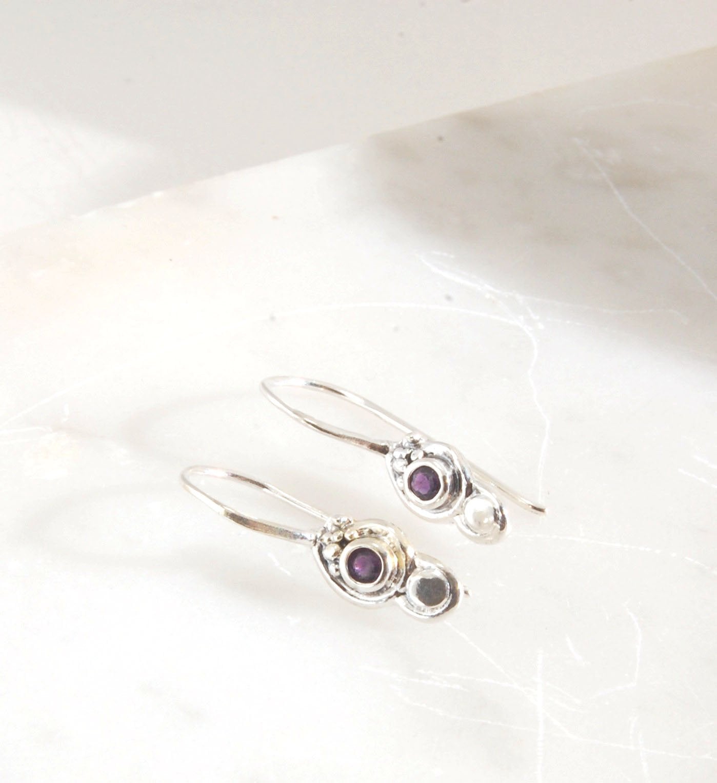 Wisteria Dangle Earrings in Amethyst, Garnet, or Topaz These delicate Wisteria earrings are cast in sterling silver from a Fine Silver granulated original. The have a fixed sterling french hook and can be set with amethyst faceted gem, garnet faceted gems