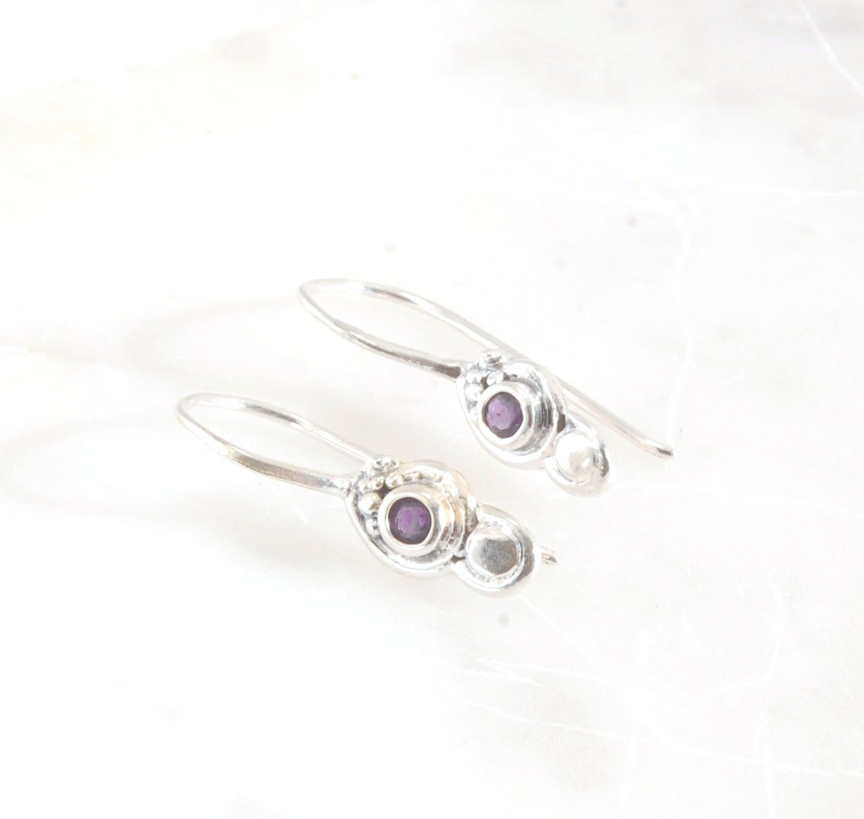 Wisteria Dangle Earrings in Amethyst, Garnet, or Topaz These delicate Wisteria earrings are cast in sterling silver from a Fine Silver granulated original. The have a fixed sterling french hook and can be set with amethyst faceted gem, garnet faceted gems