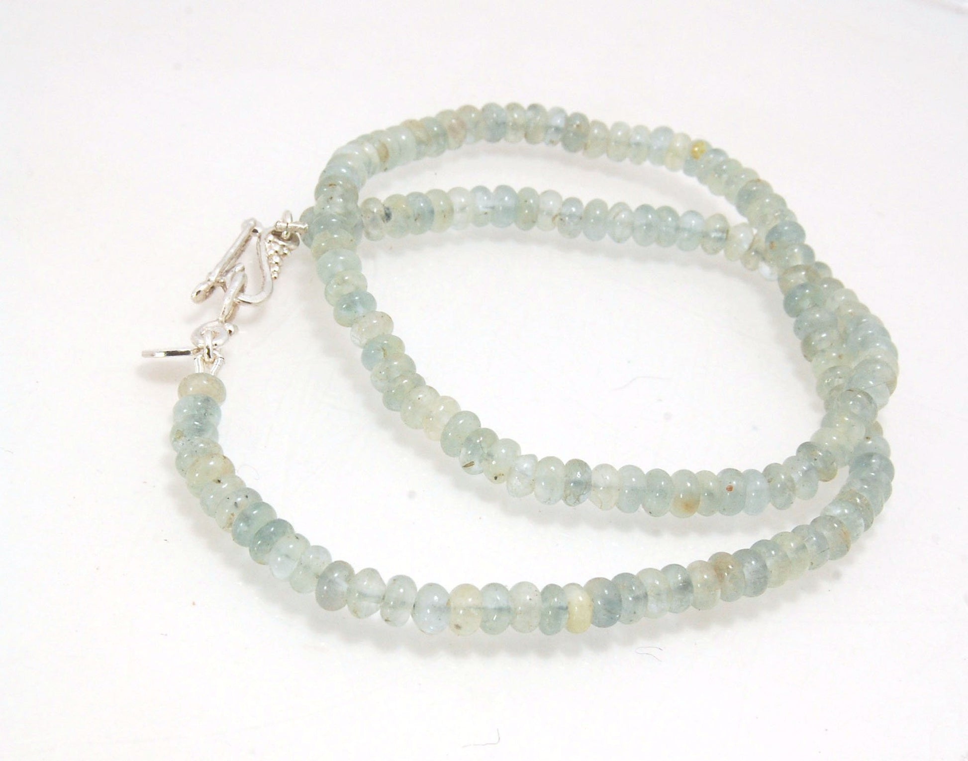 Aquamarine Gemstone Bead Strand with Granulated Sterling Silver safety clasp These ocean-colored Aquamarine rondelle gemstone beads are just lovely on! These beauties have a nice weight and warmth. I have made a sterling silver two-part safety clasp with