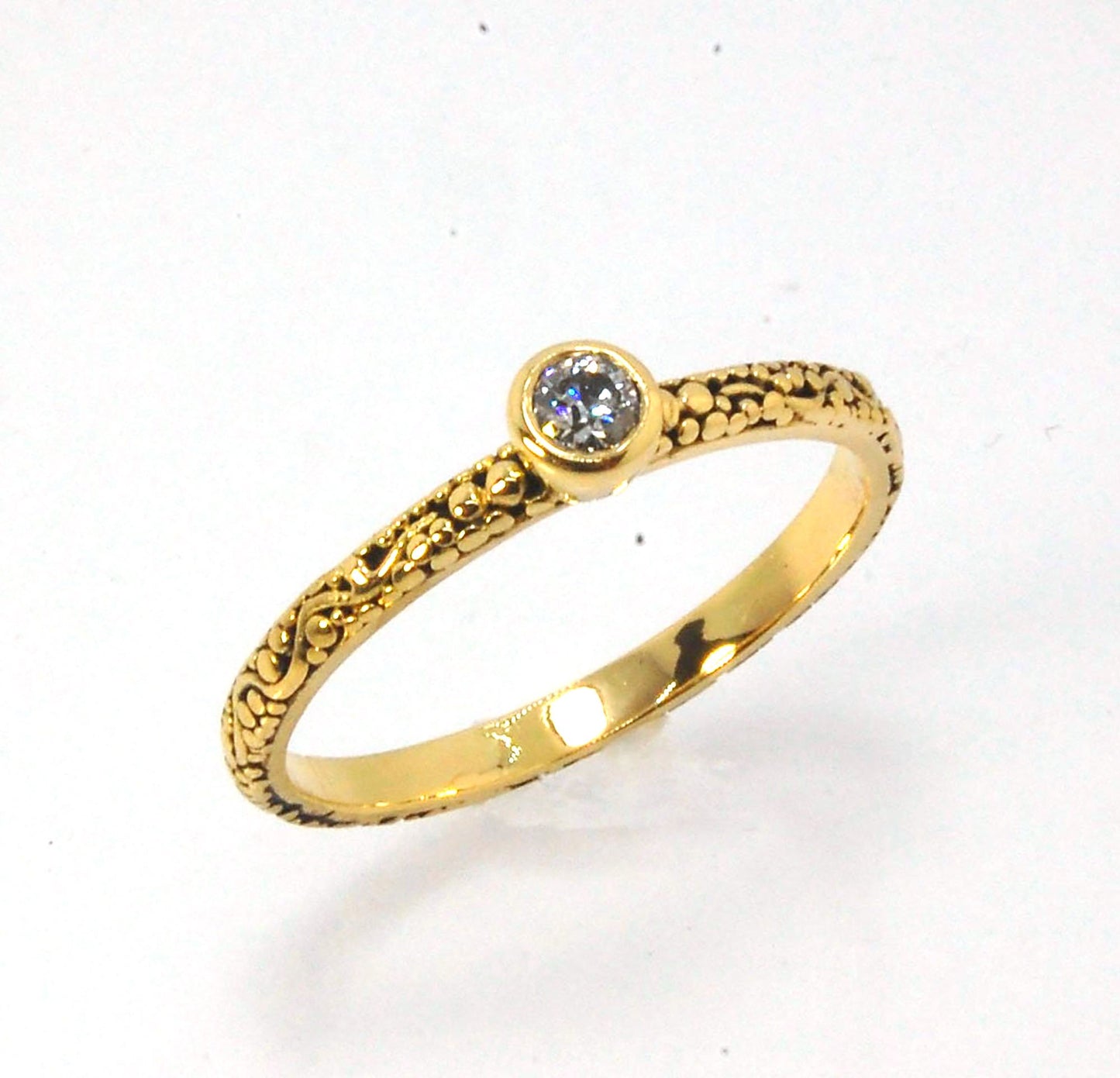 Twining Band Diamond Solitaire Ring in 18k Granulation This is a one-of-a-kind solitaire 18k ring. The twining band is 2mm wide and has a continuous pattern around made with an ancient and unique process of granulation in 18k gold alloyed in my studio. Th