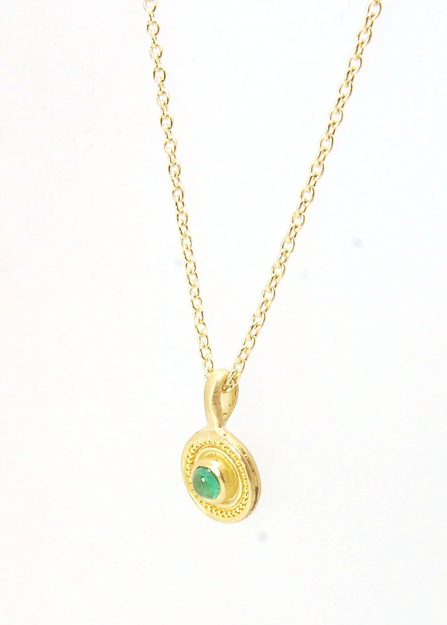 Emerald Cabochon 22k gold Tiny Granulated Disk Pendant The sweetest tiny emerald pendant yet!This lovely, luminous, ethically sourced emerald is bezel-set in 18k rich yellow gold granulation on 18k gold. Granulation is an ancient fusing process utilized f