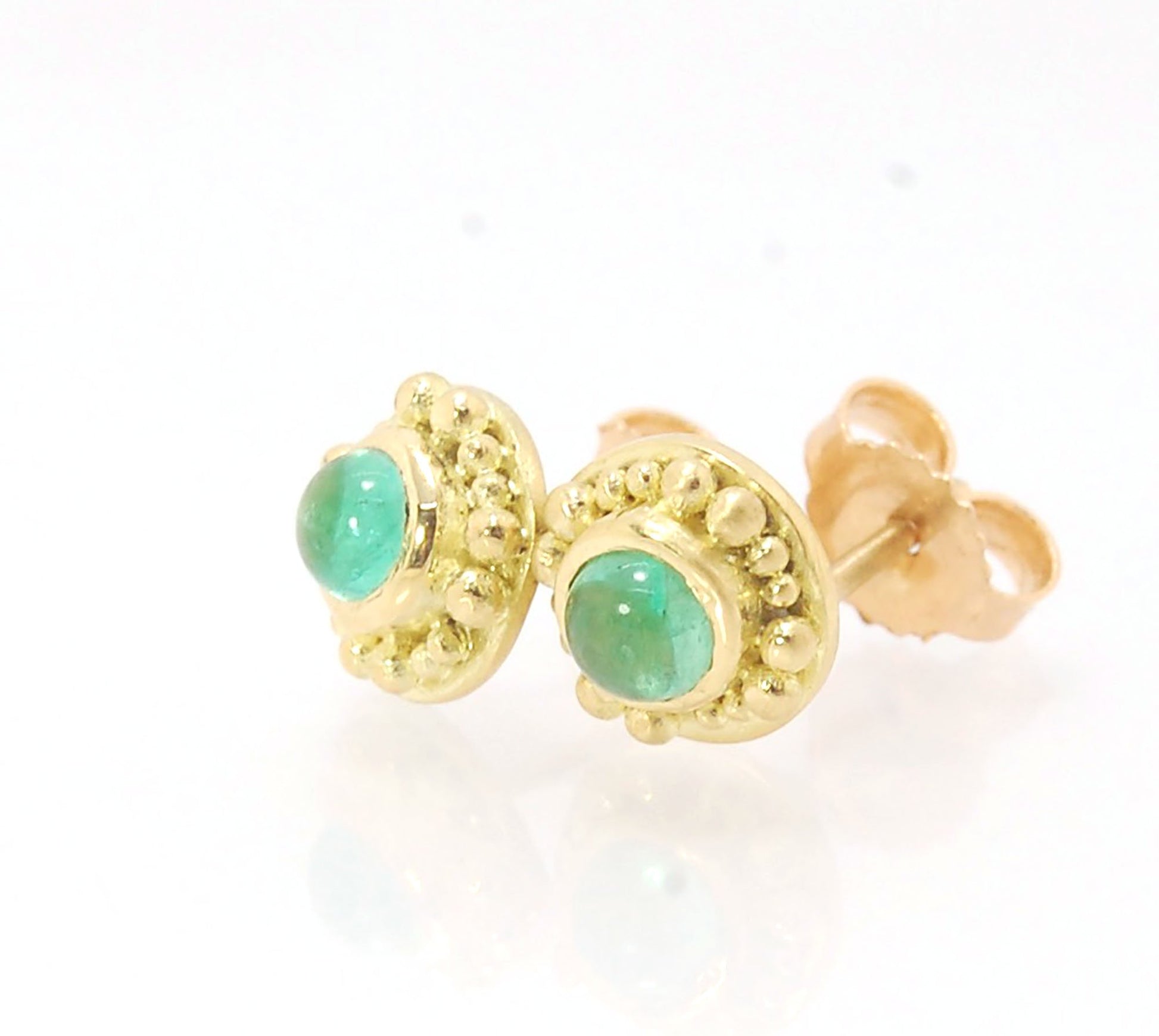 Emerald Cabochon 18k post earrings These stunning emerald cabochons are bezel-set in 18k gold with 18k granulation around the outside. These are 18k gold post earrings with a 14k gold ear nut. Classic and understated. But that color, though! Ya’ll know I