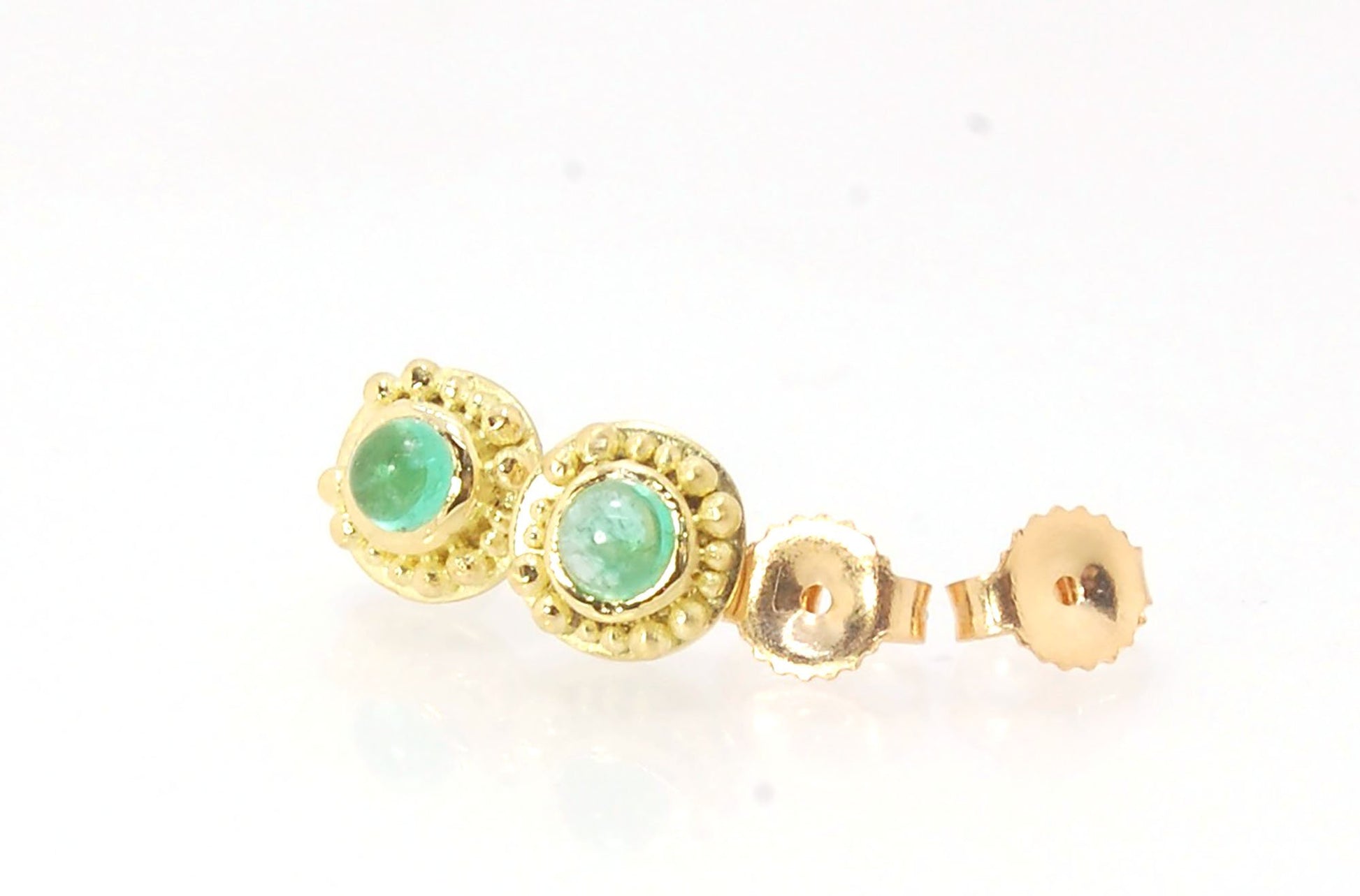 Emerald Cabochon 18k post earrings These stunning emerald cabochons are bezel-set in 18k gold with 18k granulation around the outside. These are 18k gold post earrings with a 14k gold ear nut. Classic and understated. But that color, though! Ya’ll know I