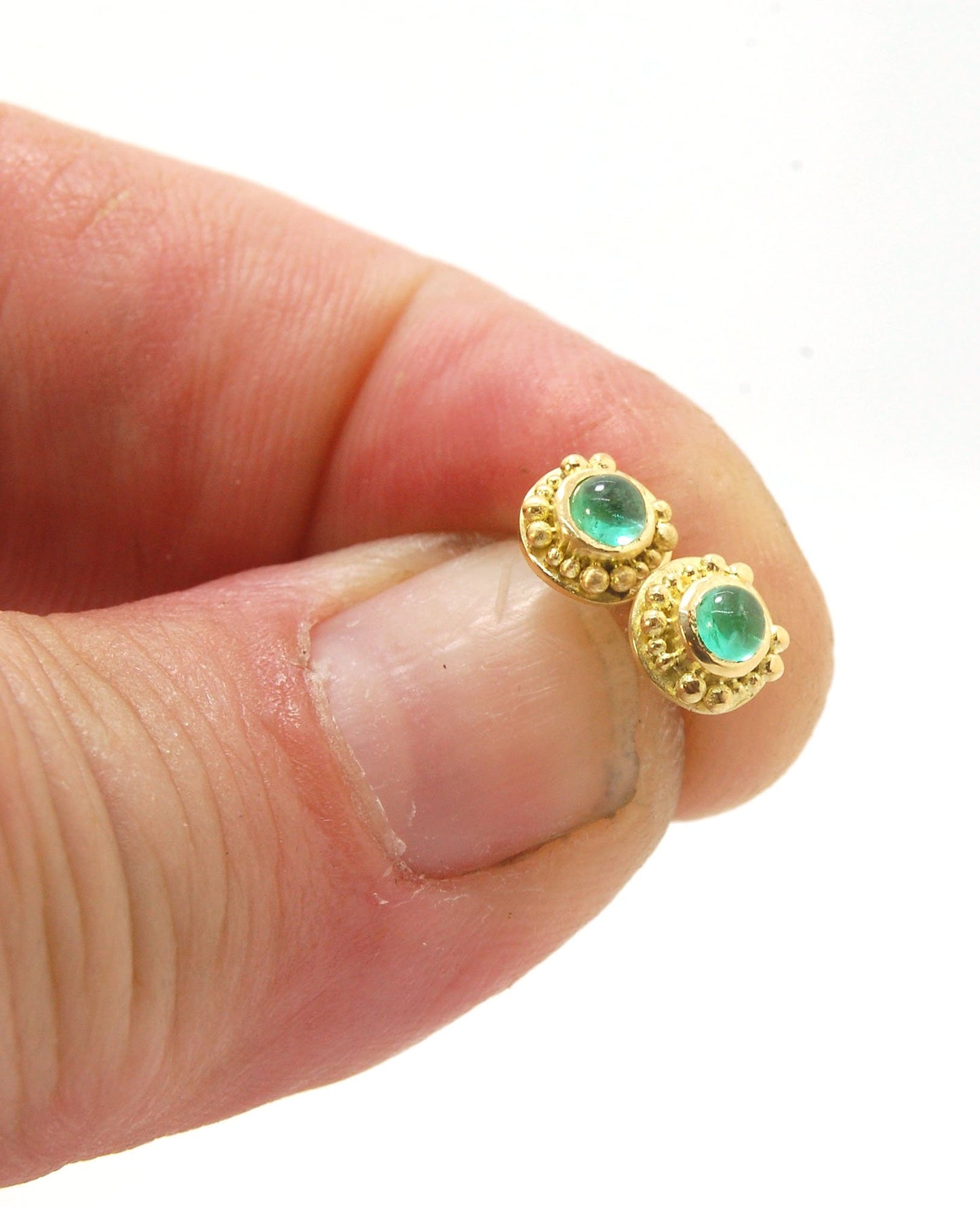 Emerald Cabochon 18k post earrings These stunning emerald cabochons are bezel-set in 18k gold with 18k granulation around the outside. These are 18k gold post earrings with a 14k gold ear nut. Classic and understated. But that color, though! Ya’ll know I