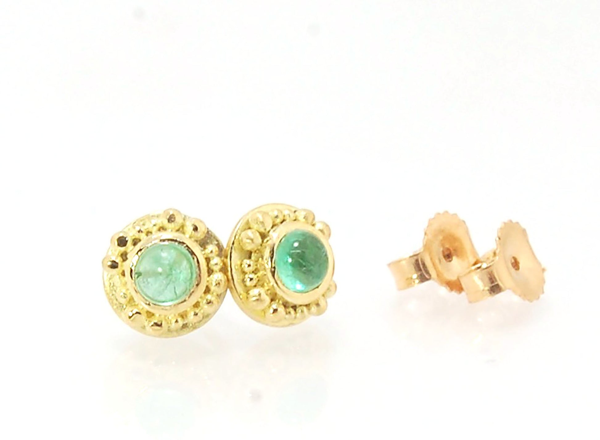 Emerald Cabochon 18k post earrings These stunning emerald cabochons are bezel-set in 18k gold with 18k granulation around the outside. These are 18k gold post earrings with a 14k gold ear nut. Classic and understated. But that color, though! Ya’ll know I