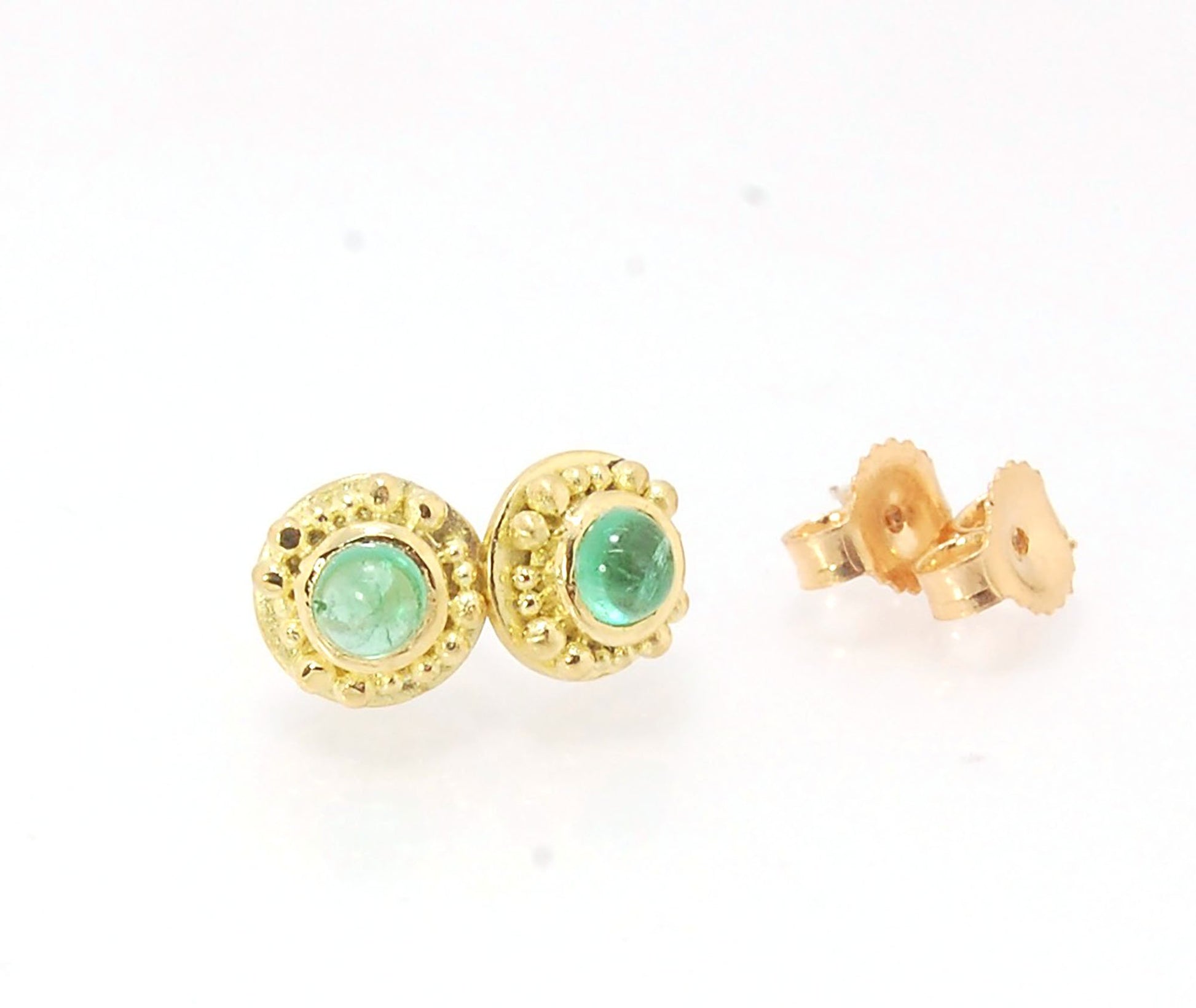 Emerald Cabochon 18k post earrings These stunning emerald cabochons are bezel-set in 18k gold with 18k granulation around the outside. These are 18k gold post earrings with a 14k gold ear nut. Classic and understated. But that color, though! Ya’ll know I