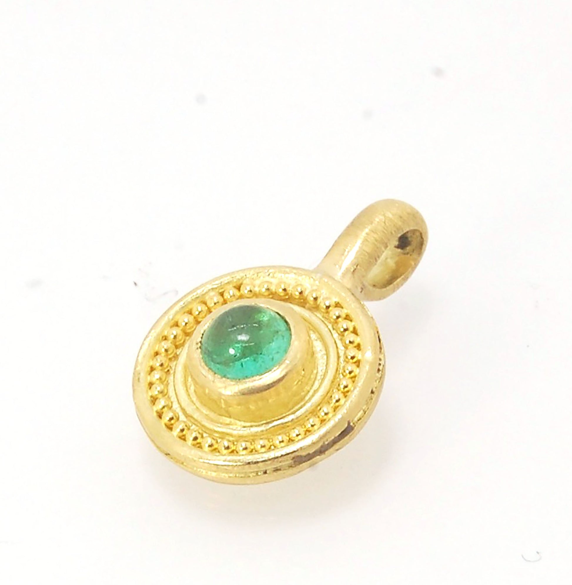 Emerald Cabochon 22k gold Tiny Granulated Disk Pendant The sweetest tiny emerald pendant yet!This lovely, luminous, ethically sourced emerald is bezel-set in 18k rich yellow gold granulation on 18k gold. Granulation is an ancient fusing process utilized f