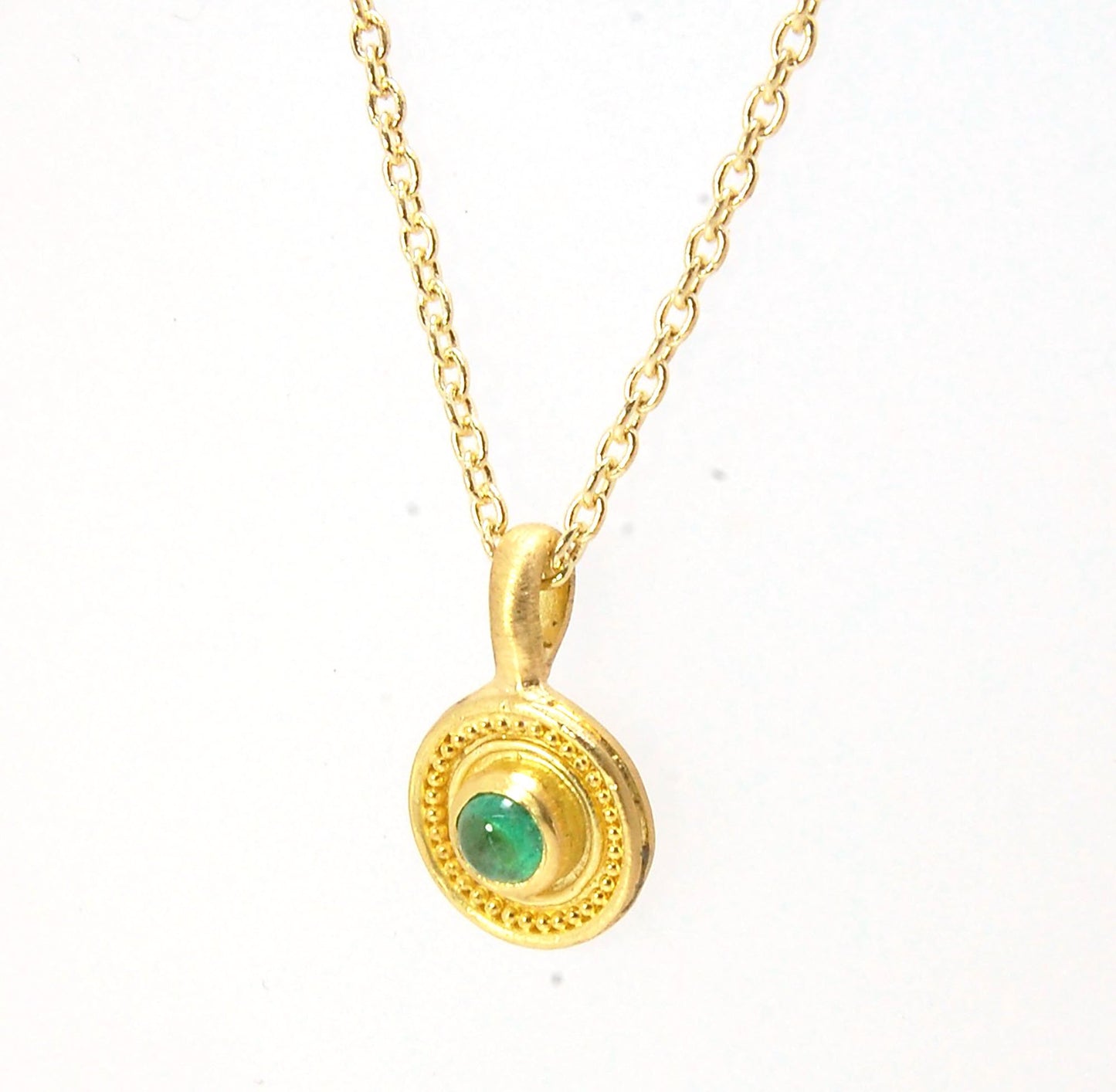 Emerald Cabochon 22k gold Tiny Granulated Disk Pendant The sweetest tiny emerald pendant yet!This lovely, luminous, ethically sourced emerald is bezel-set in 18k rich yellow gold granulation on 18k gold. Granulation is an ancient fusing process utilized f