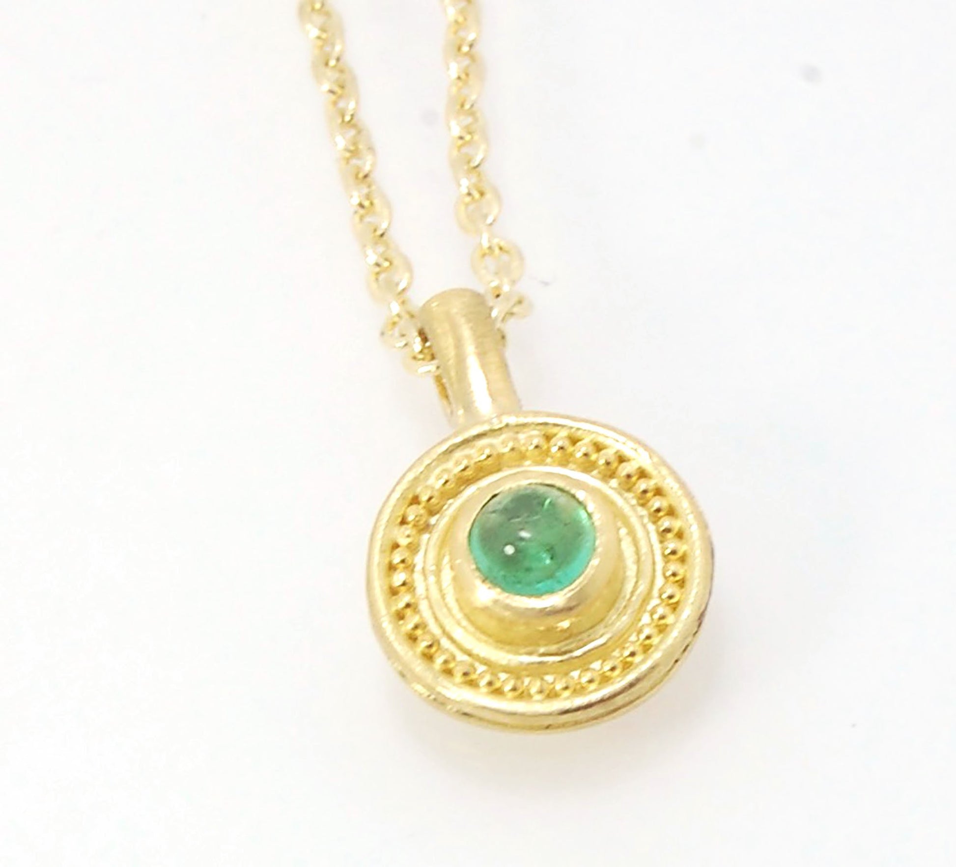 Emerald Cabochon 22k gold Tiny Granulated Disk Pendant The sweetest tiny emerald pendant yet!This lovely, luminous, ethically sourced emerald is bezel-set in 18k rich yellow gold granulation on 18k gold. Granulation is an ancient fusing process utilized f