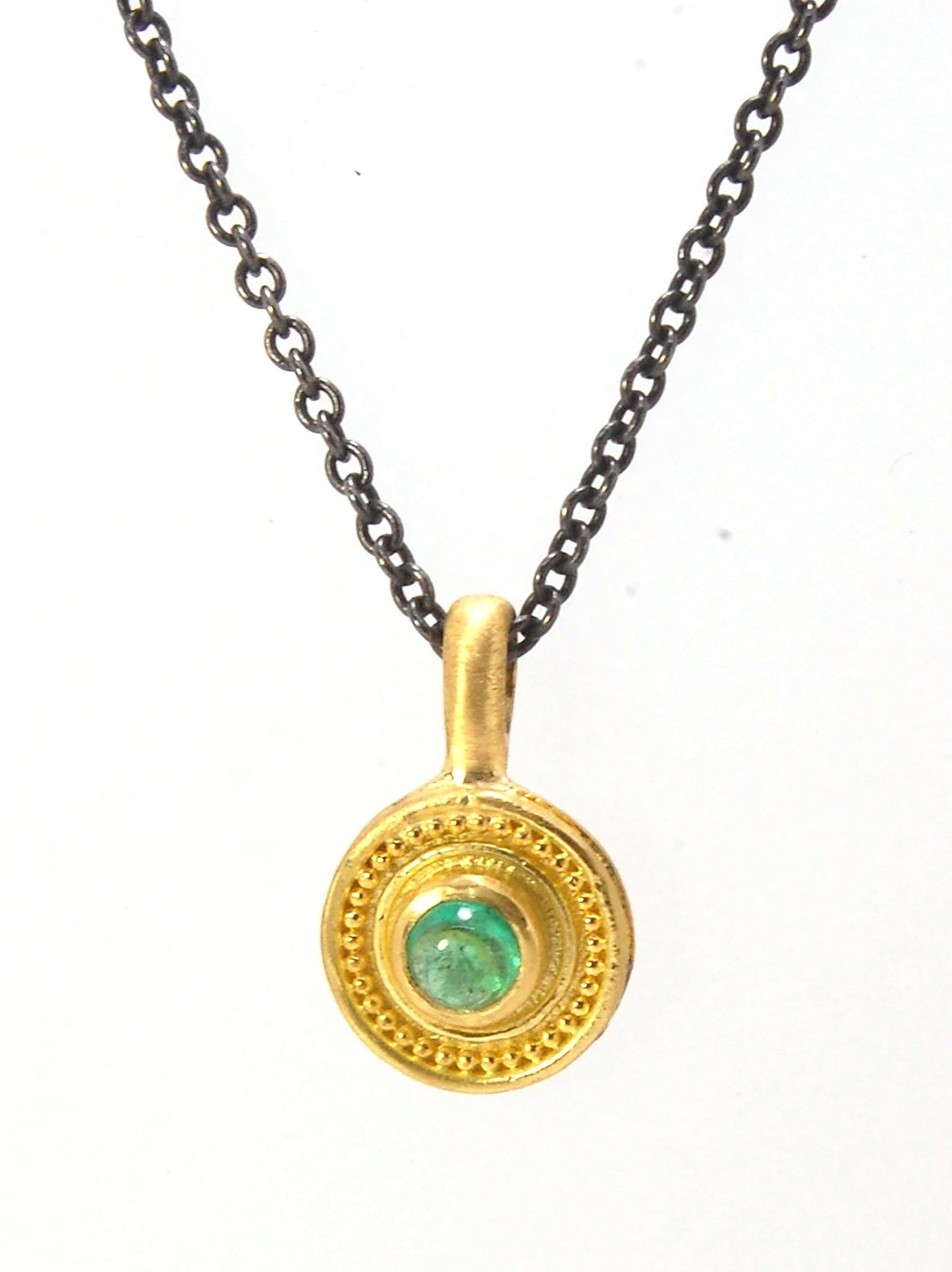 Emerald Cabochon 22k gold Tiny Granulated Disk Pendant The sweetest tiny emerald pendant yet!This lovely, luminous, ethically sourced emerald is bezel-set in 18k rich yellow gold granulation on 18k gold. Granulation is an ancient fusing process utilized f