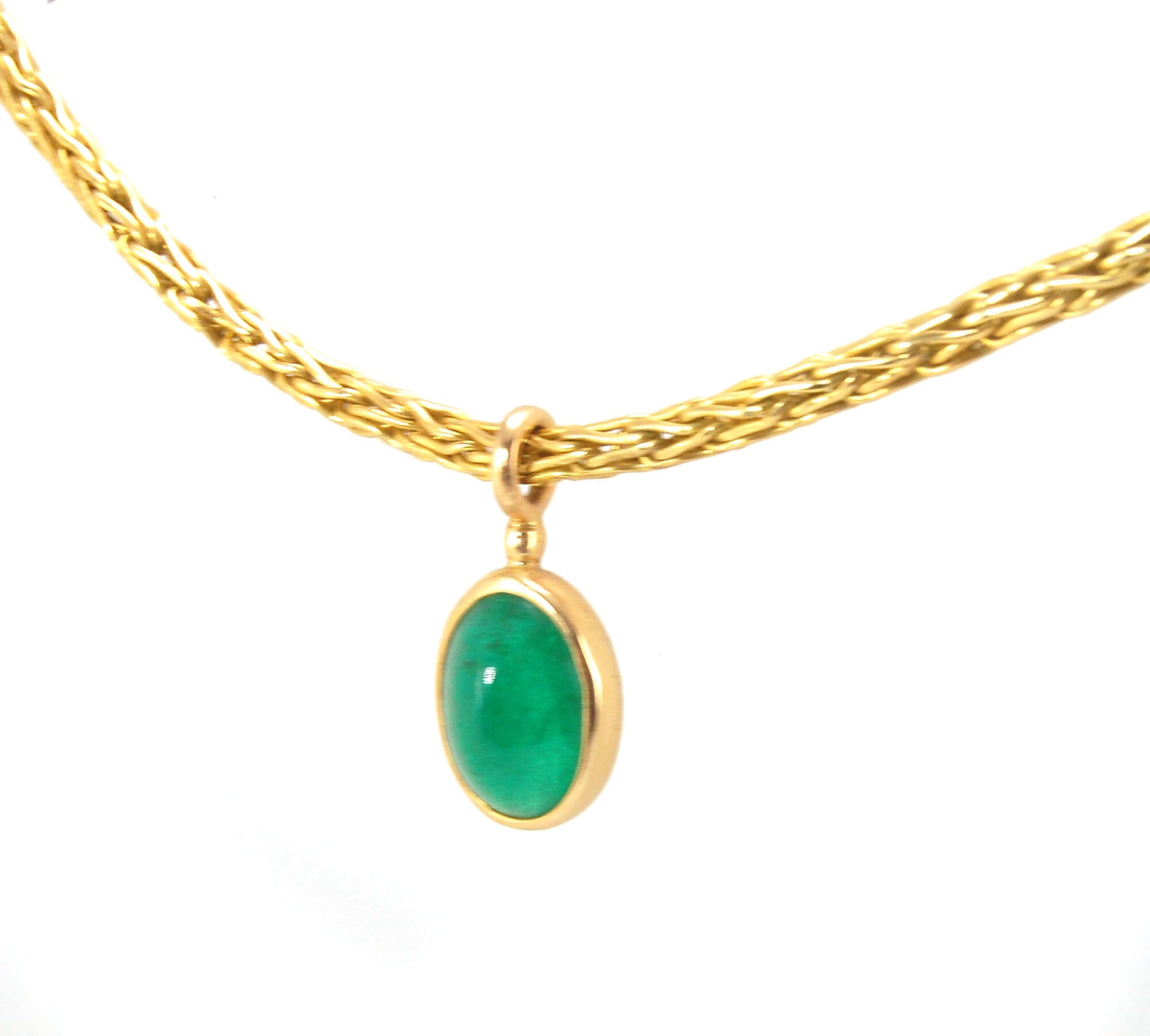 Emerald Cabochon on Handmade Woven 18k gold chain This clear emerald cabochon is bezel-set in 18k gold and suspended from a handmade woven chain of 18k gold in ancient Viking knit. A forged hook clasp finishes this simple and elegant design. Emerald Caboc