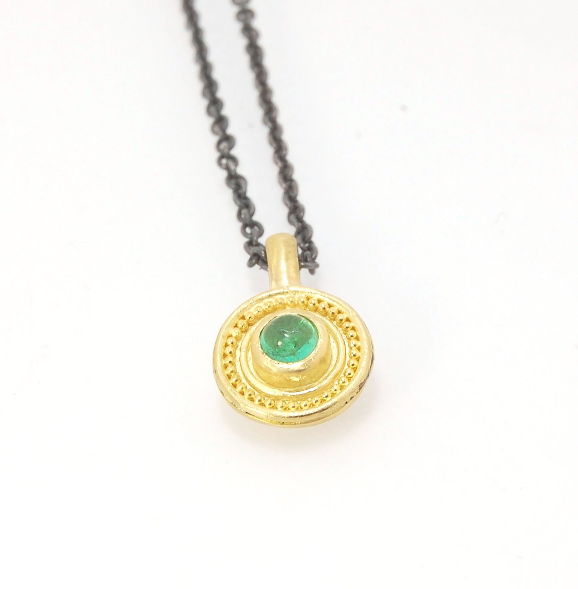 Emerald Cabochon 22k gold Tiny Granulated Disk Pendant The sweetest tiny emerald pendant yet!This lovely, luminous, ethically sourced emerald is bezel-set in 18k rich yellow gold granulation on 18k gold. Granulation is an ancient fusing process utilized f